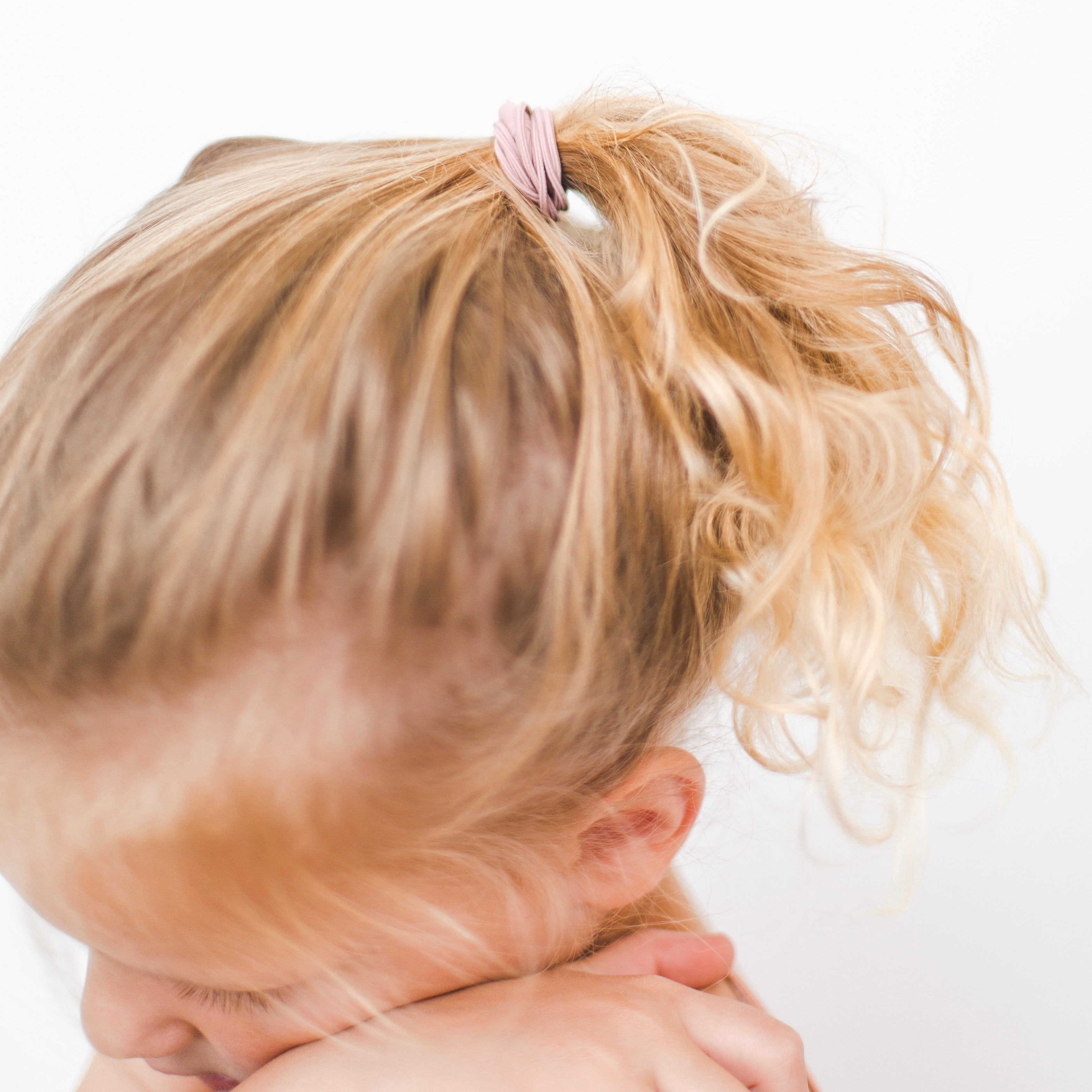 Girl putting Cutie Bangles in her hair.