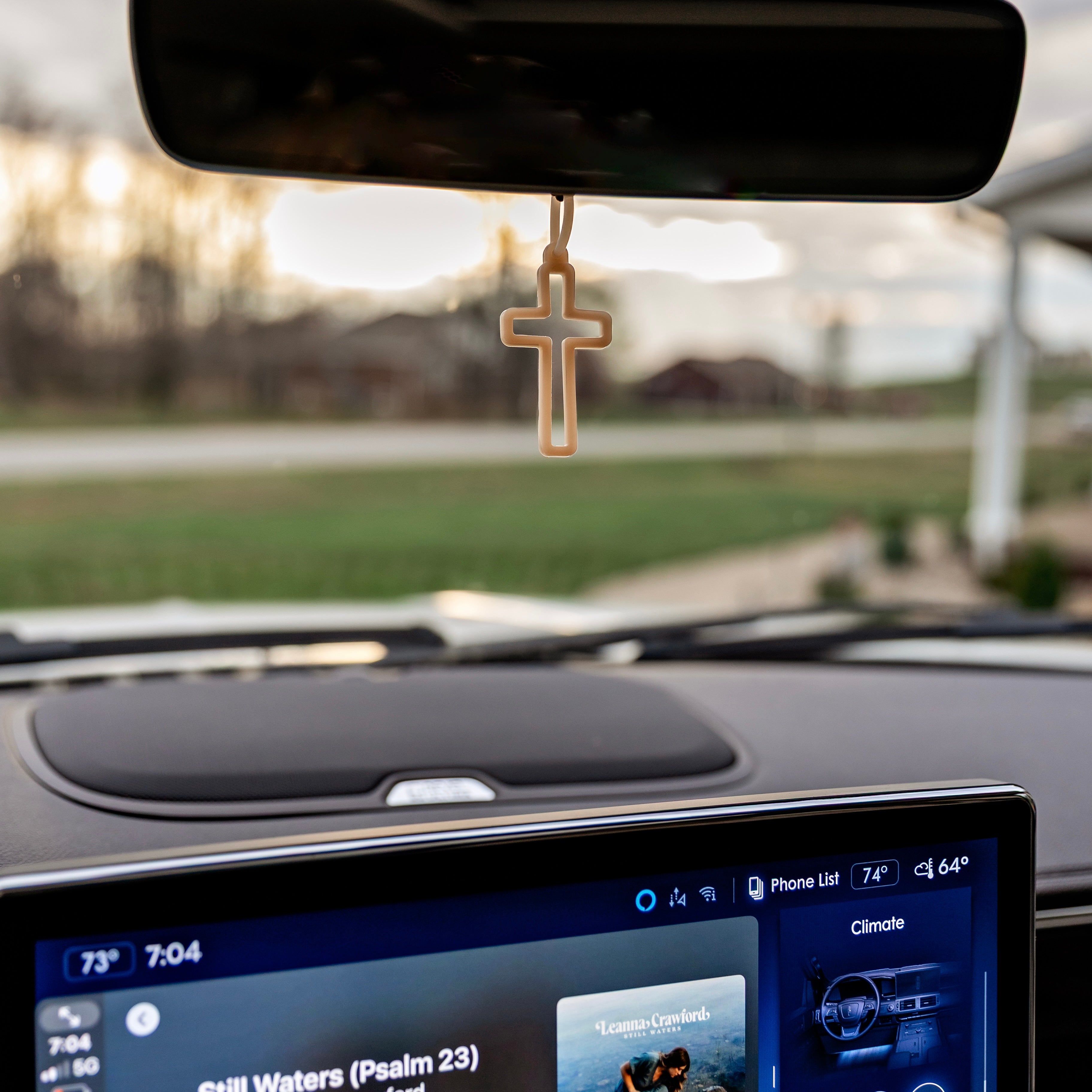Cross charm on car mirror