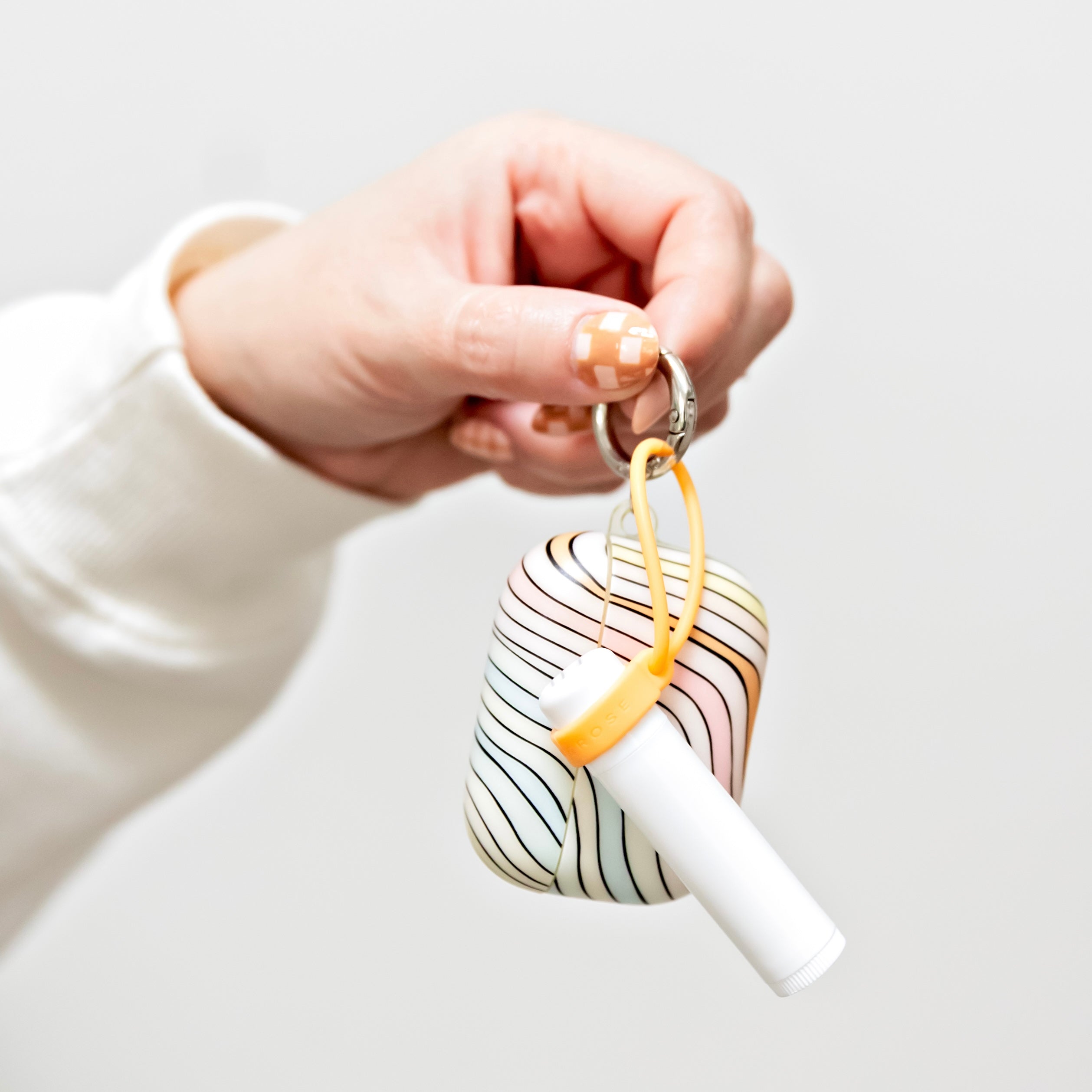 Woman holding lip balm holder and AirPods