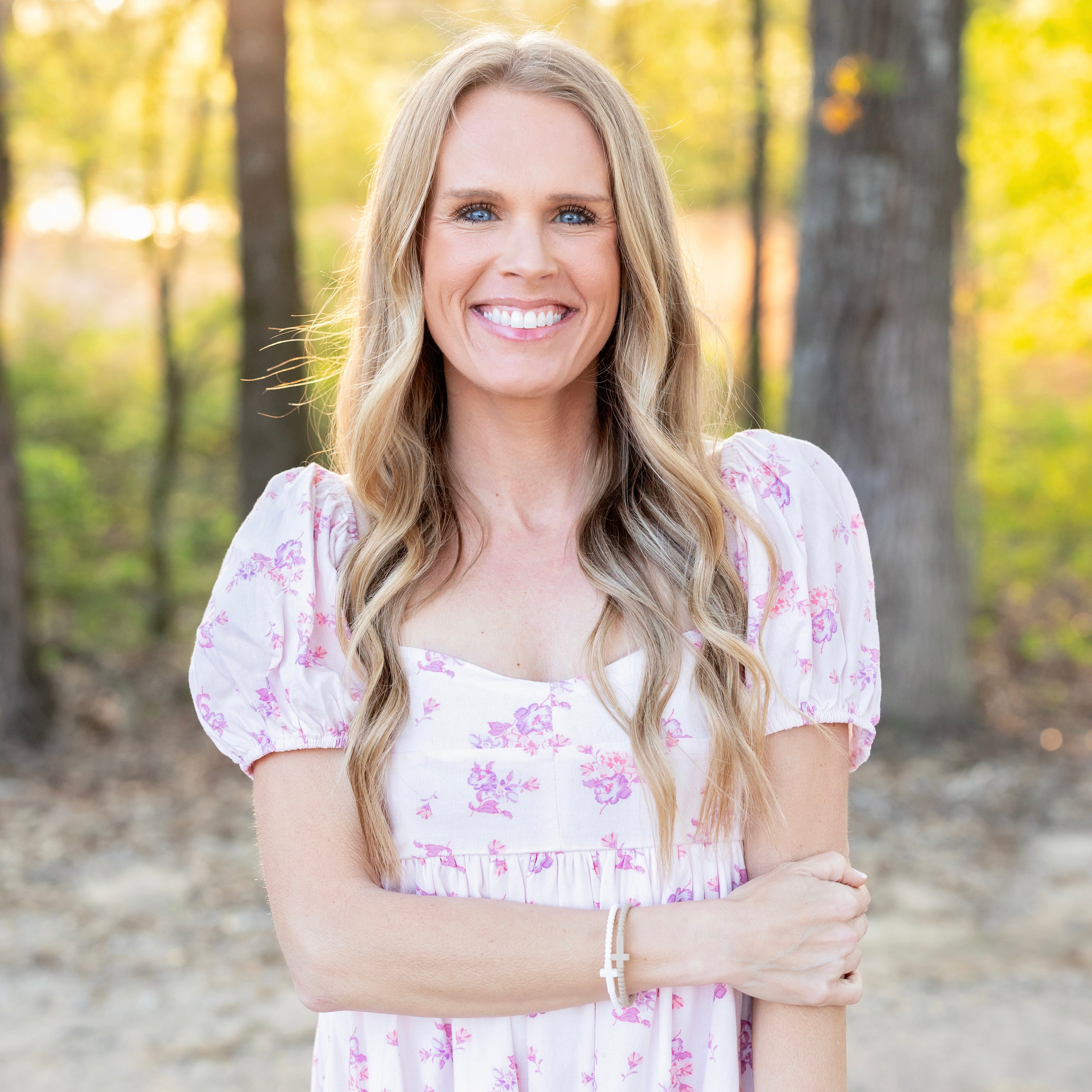 Woman in a floral dress standing in a forest