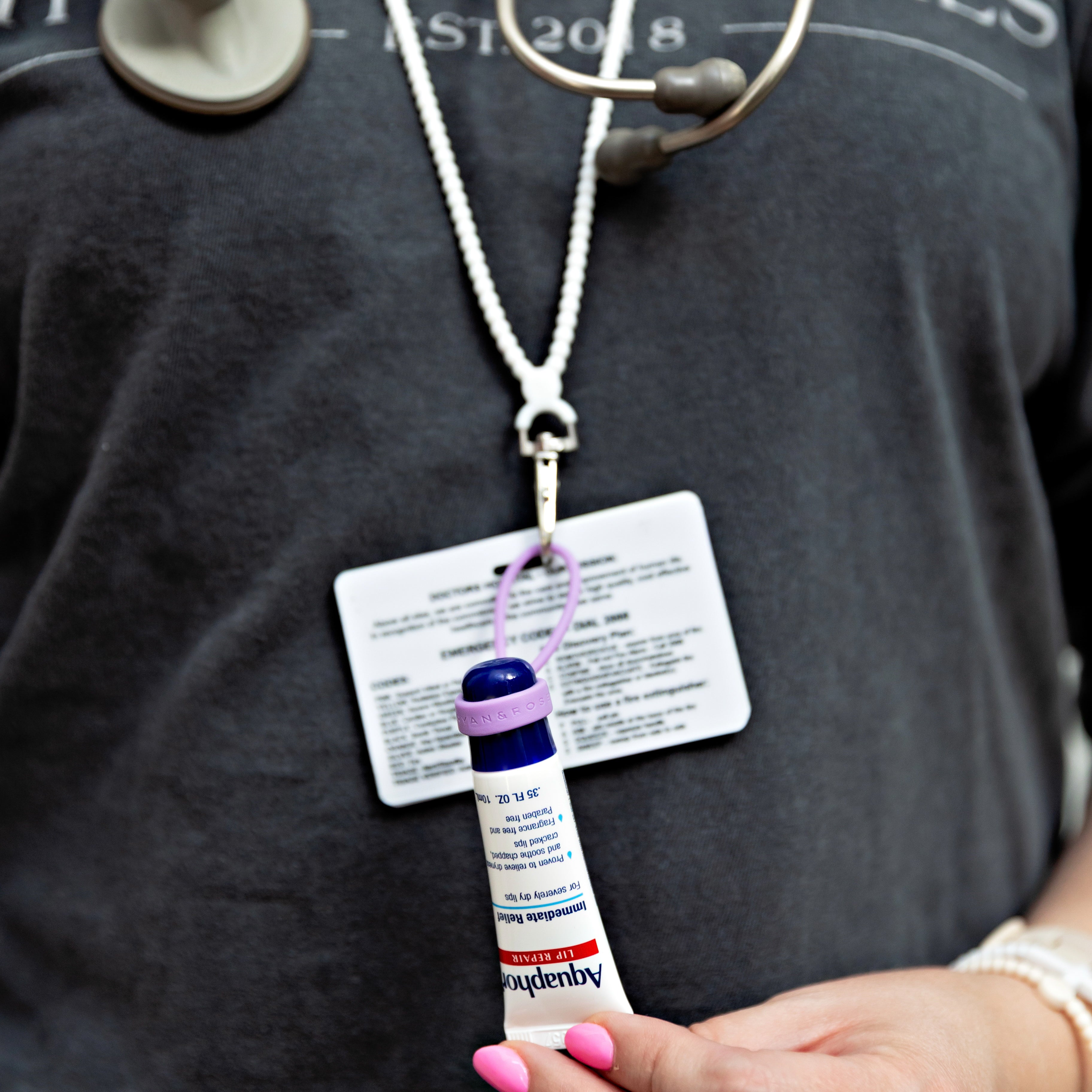 Woman wearing a lanyard with a chapstick attached
