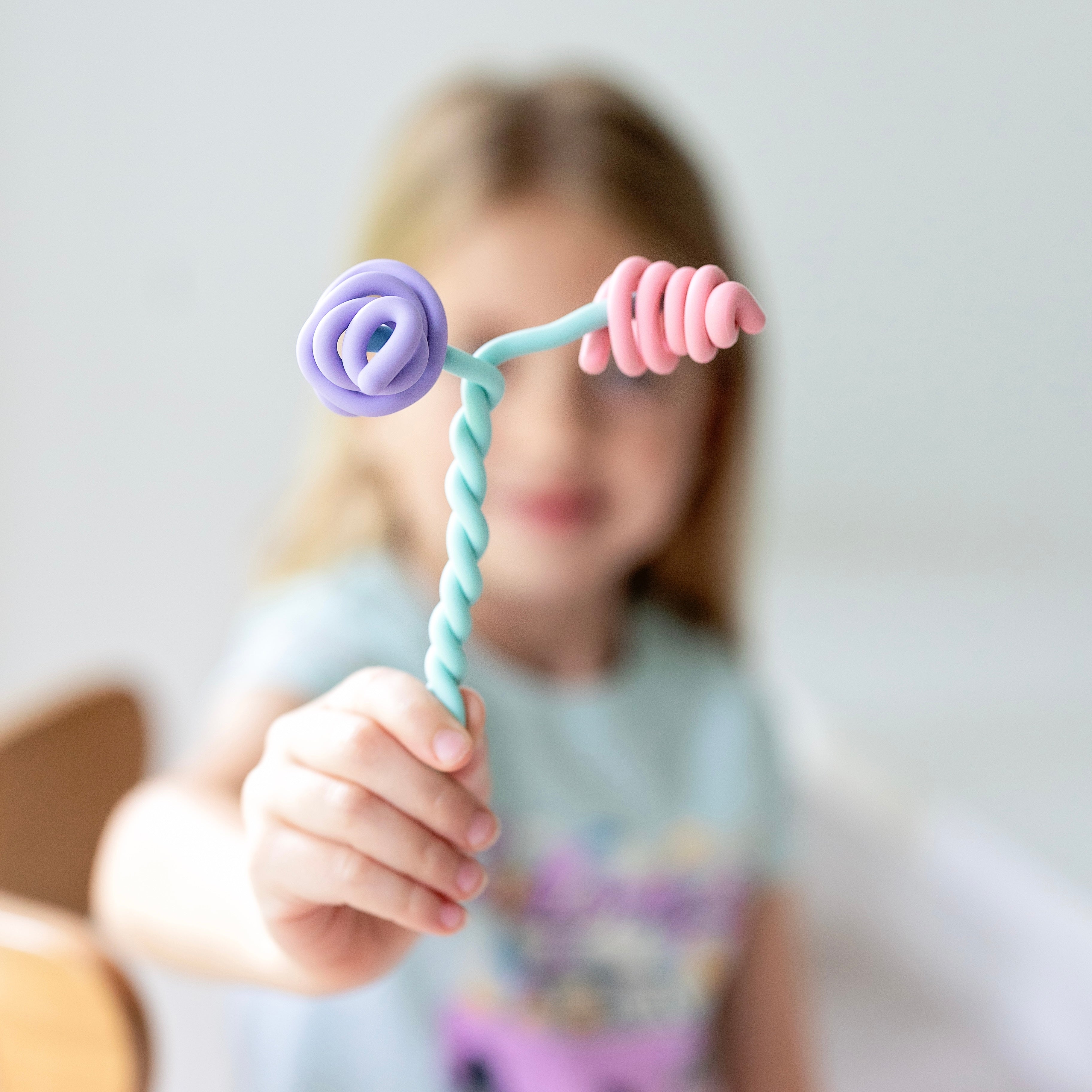Child holding a colorful toy with a blurred background
