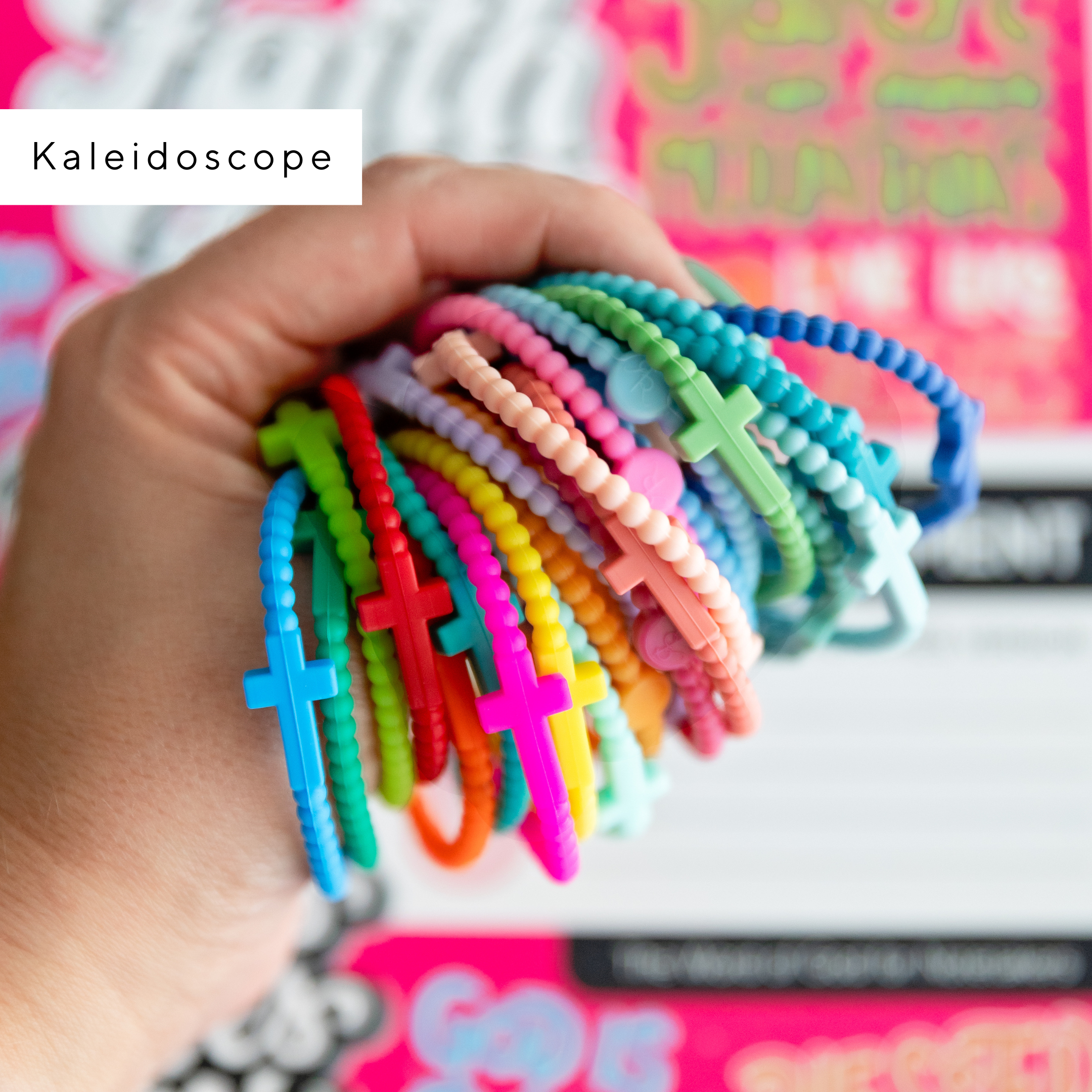 Colorful beaded bracelets held by a hand with a pink and white background
