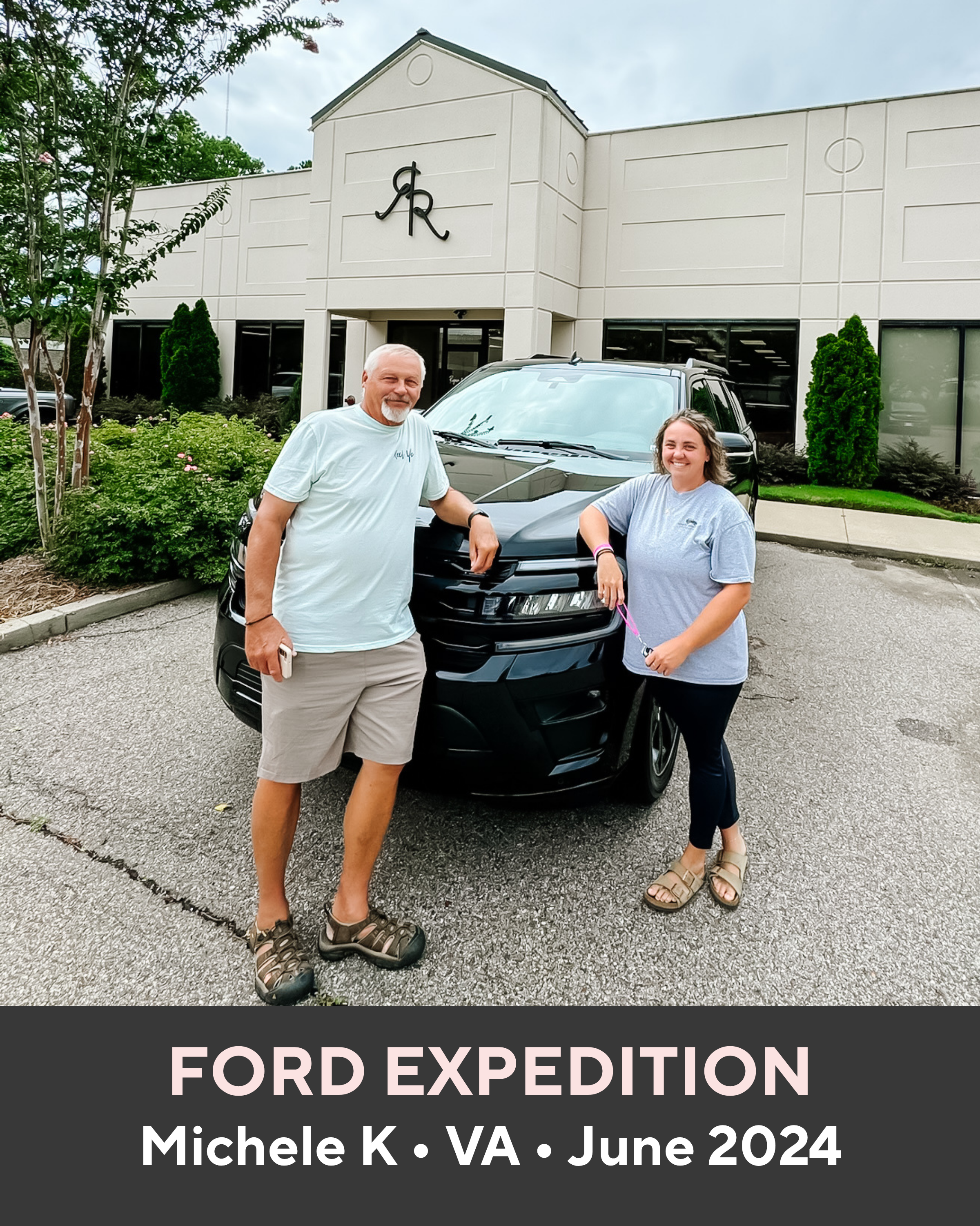 Two people standing next to a black Ford Expedition in front of a building with a logo.