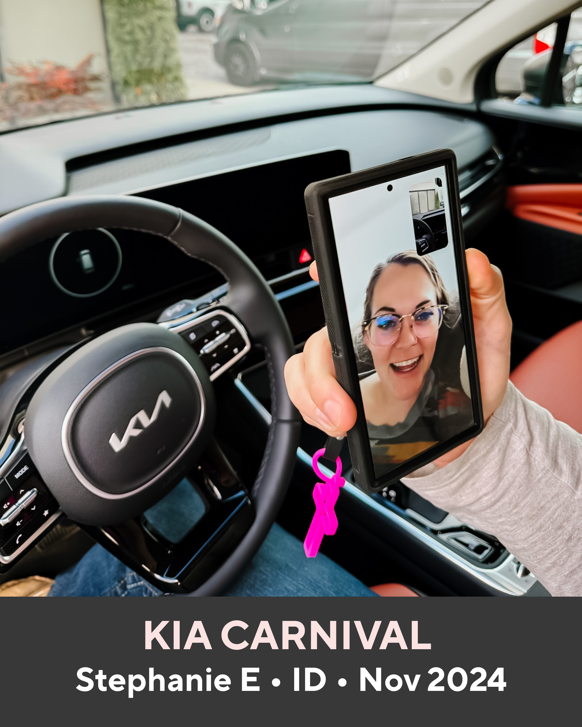 Person inside a Kia Carnival holding a phone with a video call, with the car's steering wheel and dashboard visible.