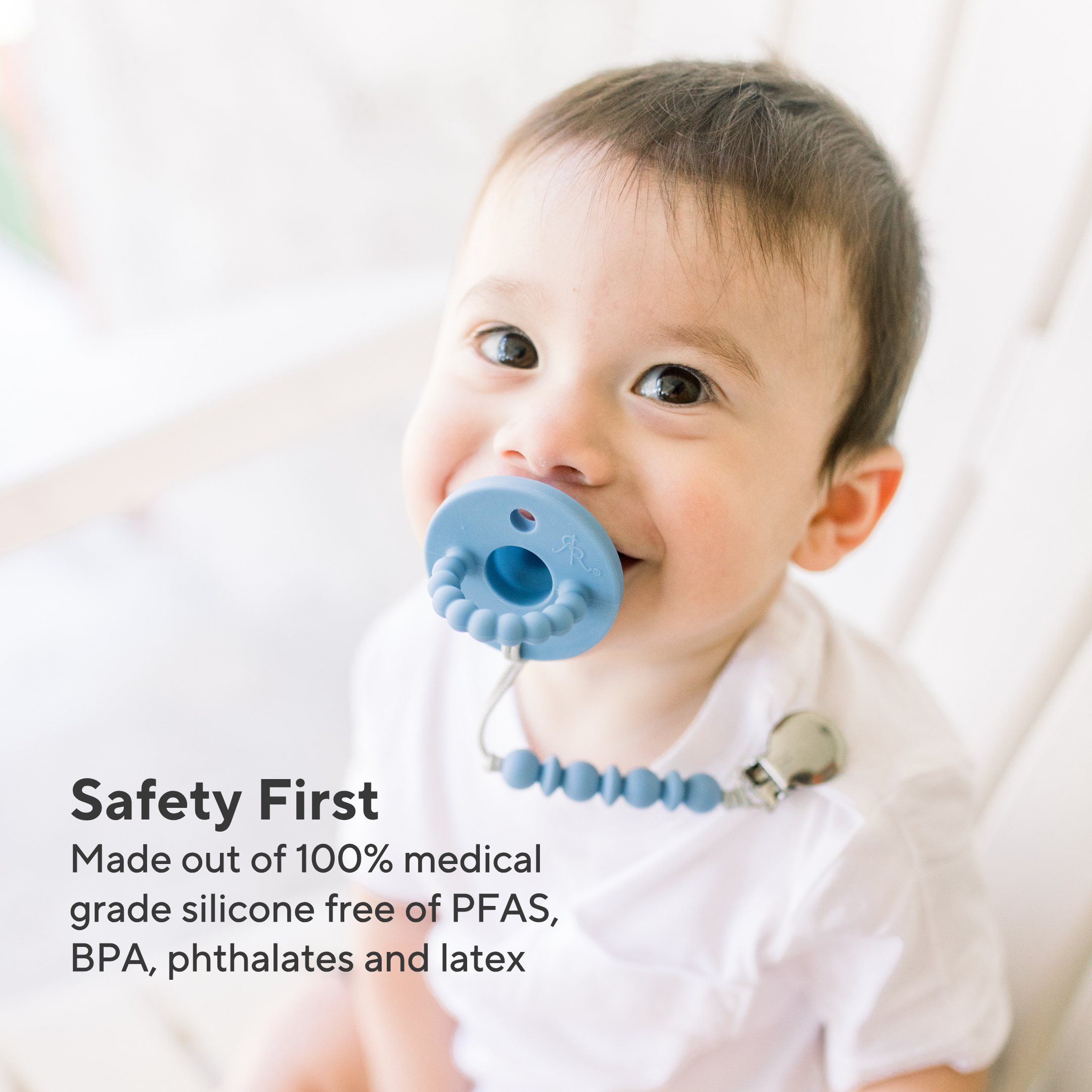 Baby wearing a blue pacifier with text about safety and material composition.