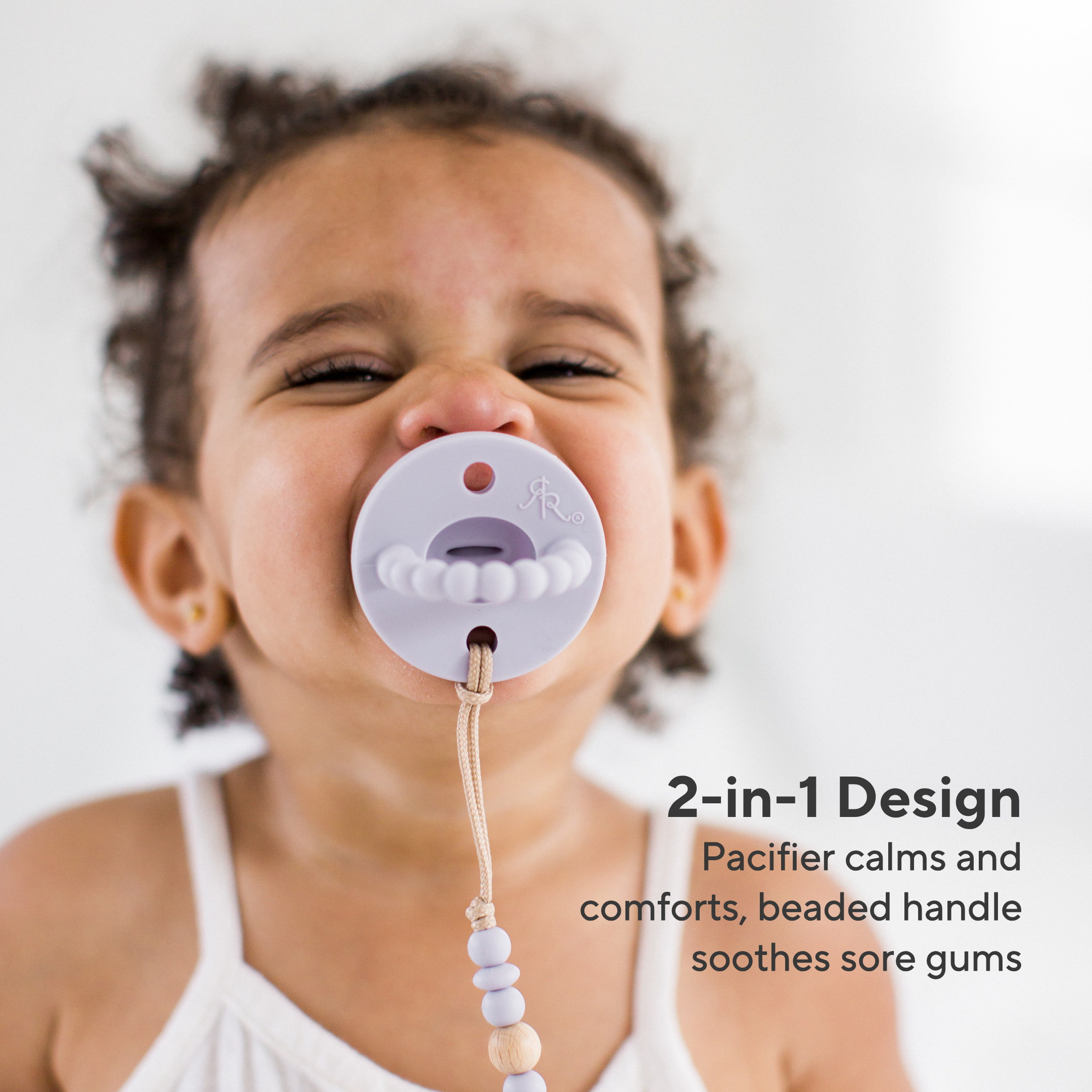 Child with a pacifier featuring a beaded handle on a white background