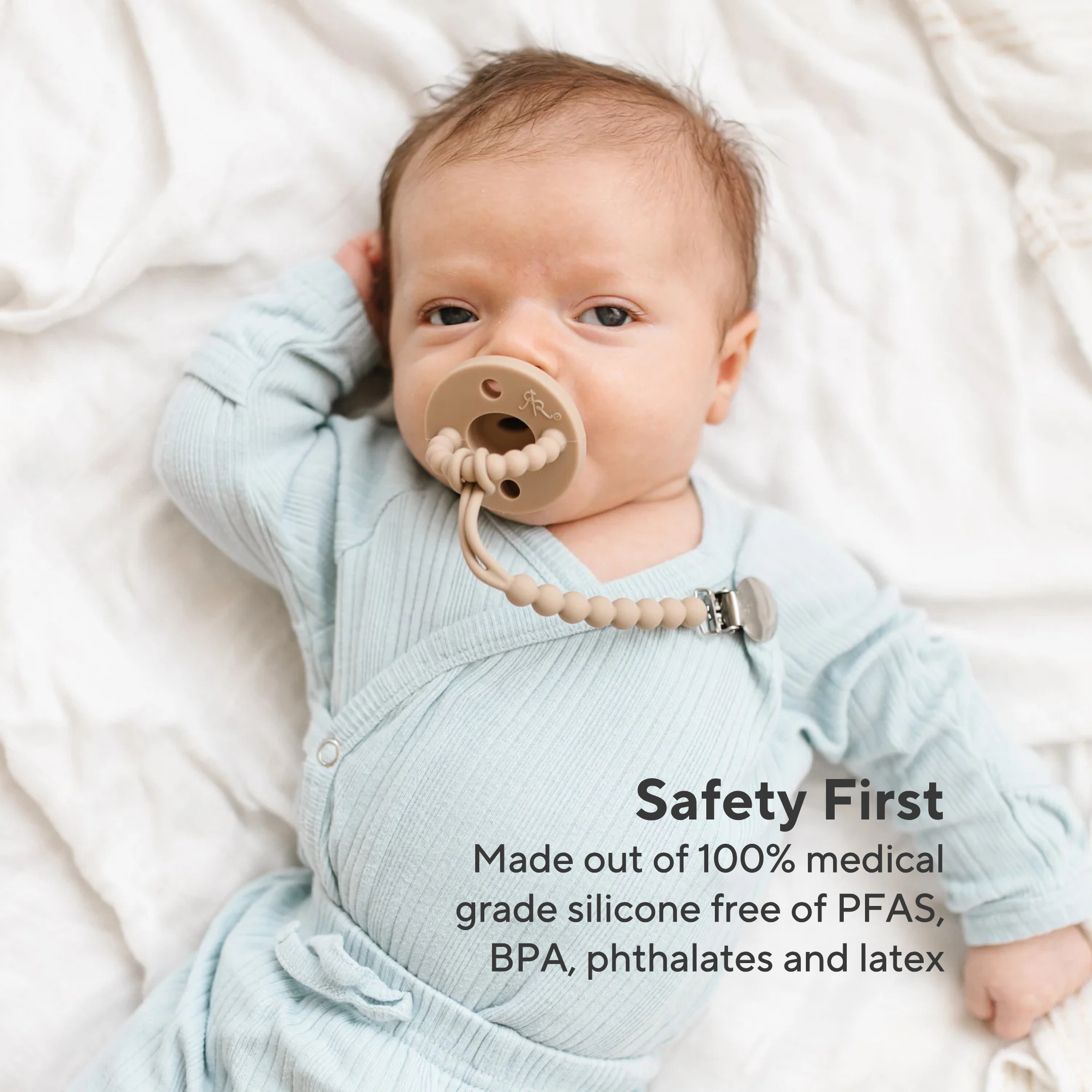 Baby wearing a pacifier with text about product safety and material composition.