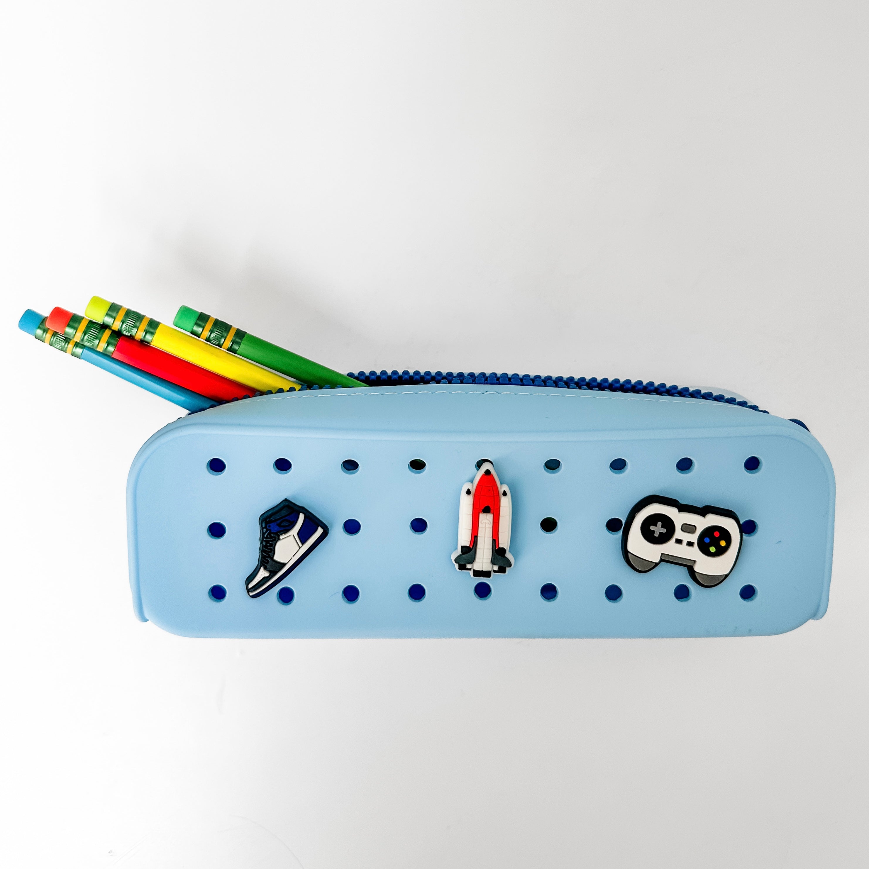 Blue pegboard pencil case with decorative pins on a white background