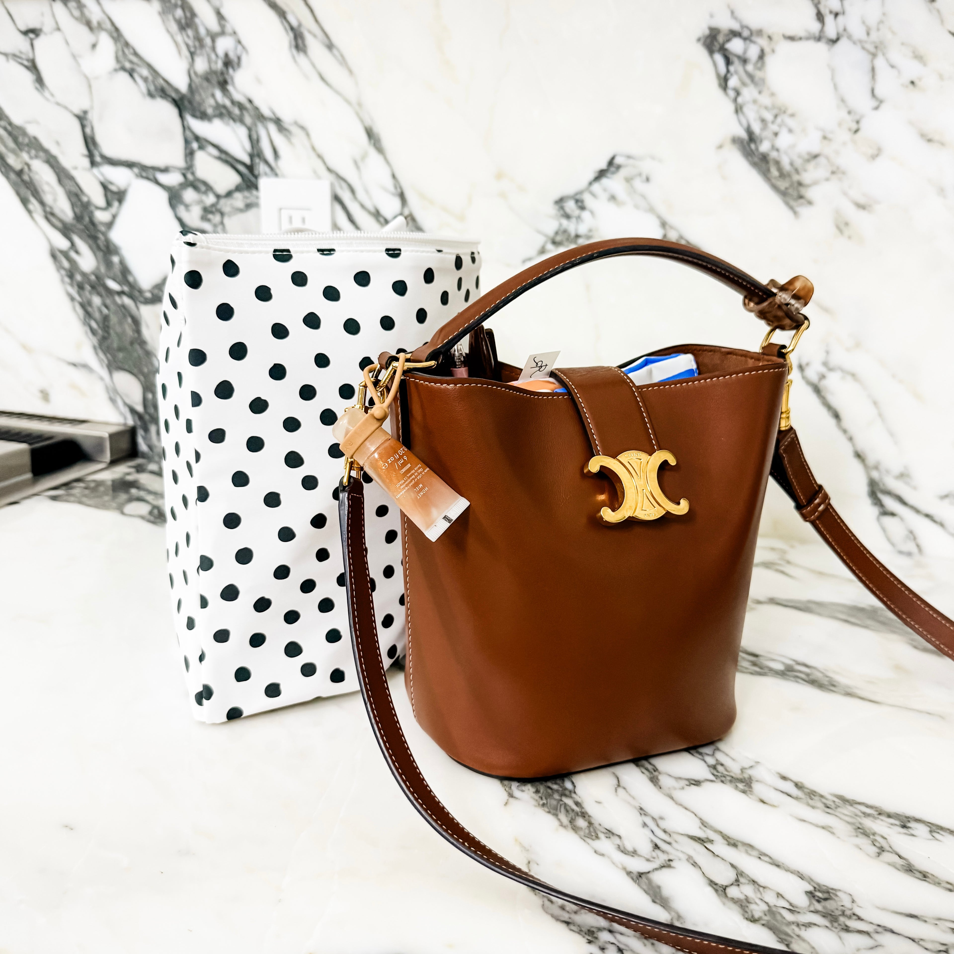 Brown handbag with gold clasp on a marble surface