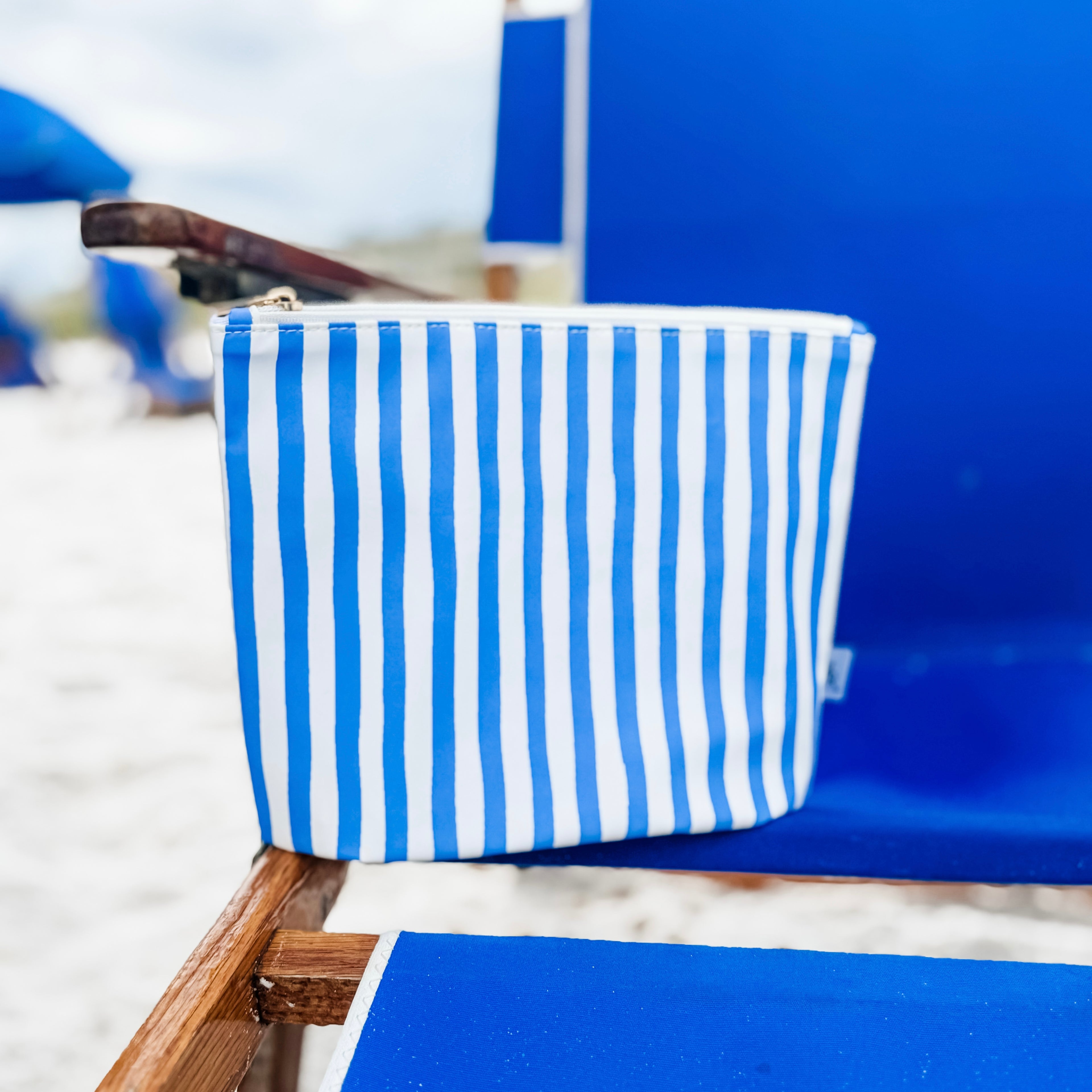 Blue and white striped pouch on a blue chair at the beach