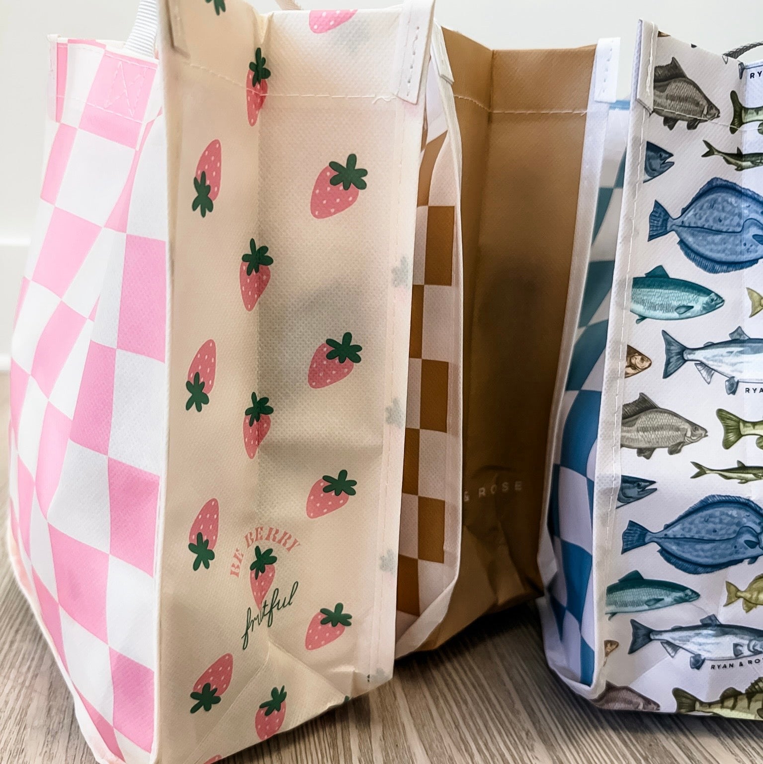 Three fabric bags with different patterns on a wooden surface.