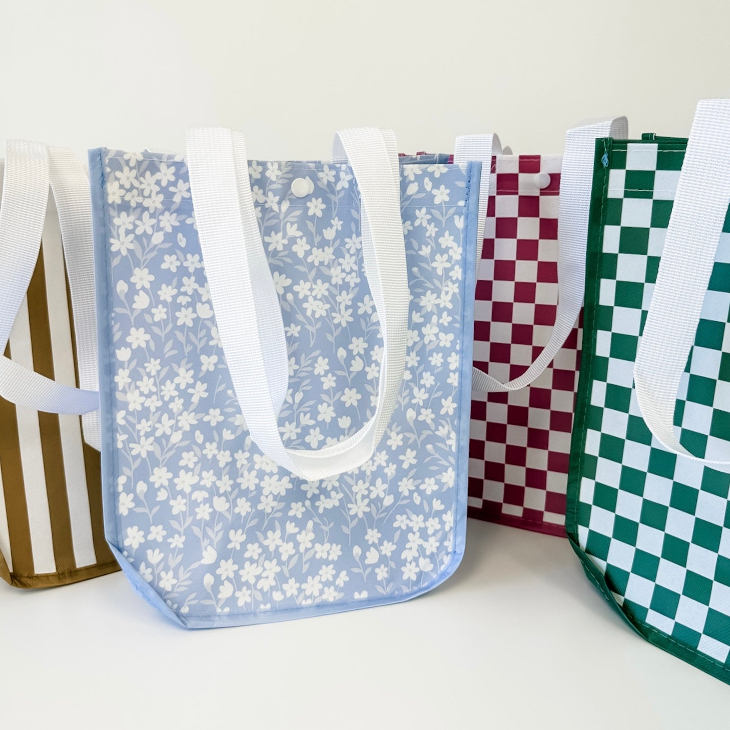 Set of patterned bags including floral, checkered, and striped designs on a white background.