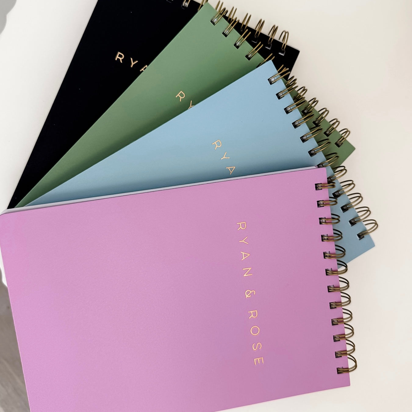 Set of spiral-bound notebooks in various colors with &