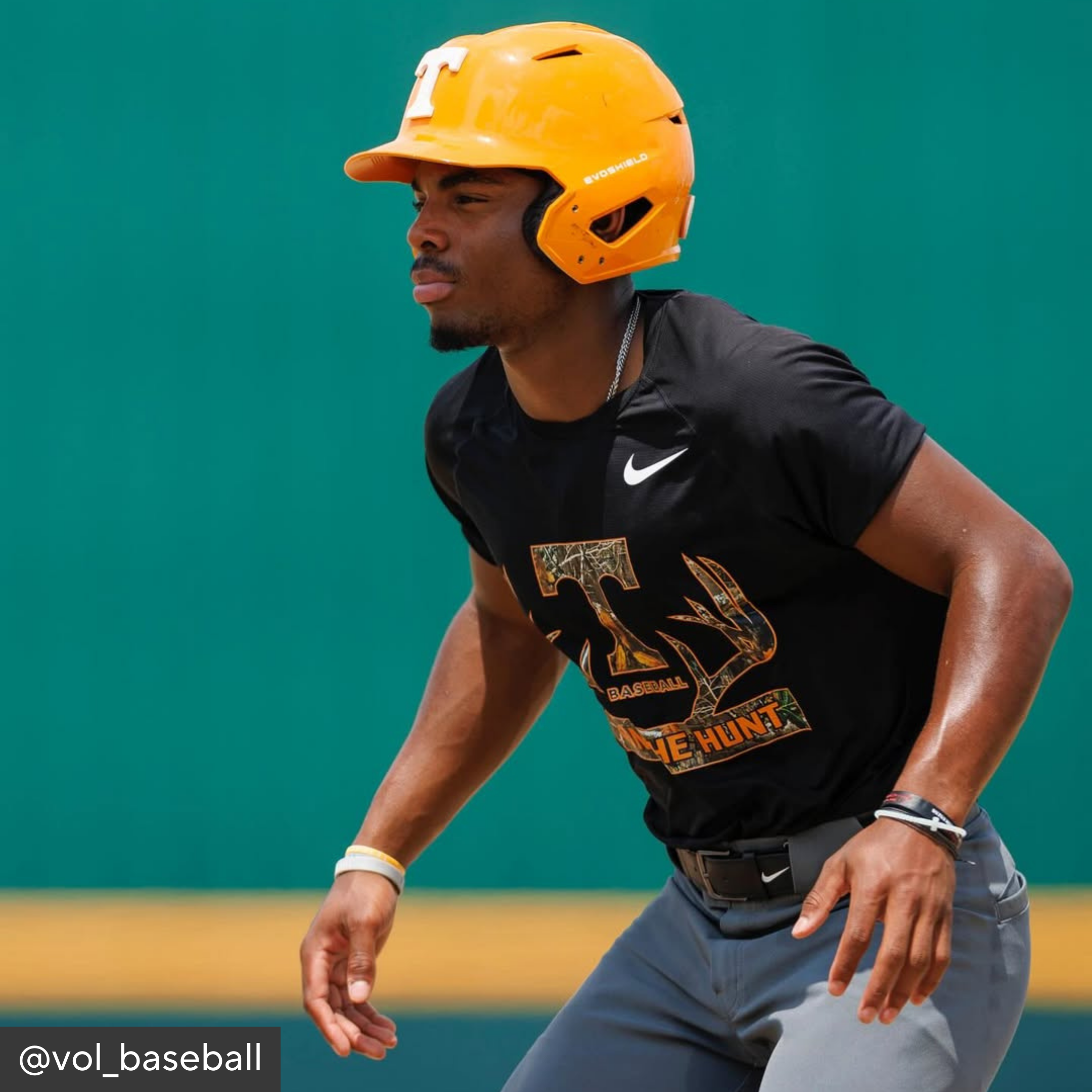 Baseball player in black jersey and yellow helmet on a field