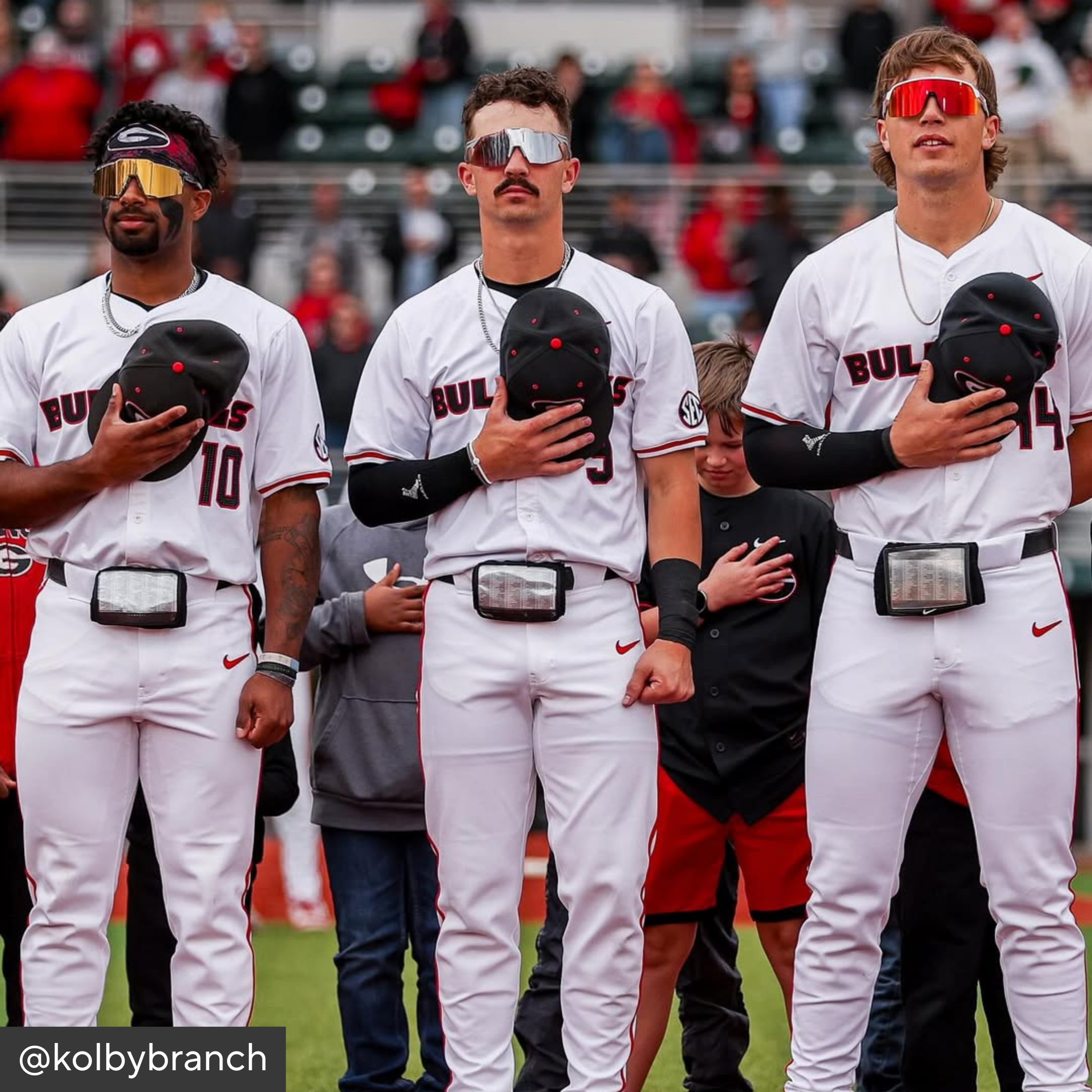 Three baseball players in white uniforms with &