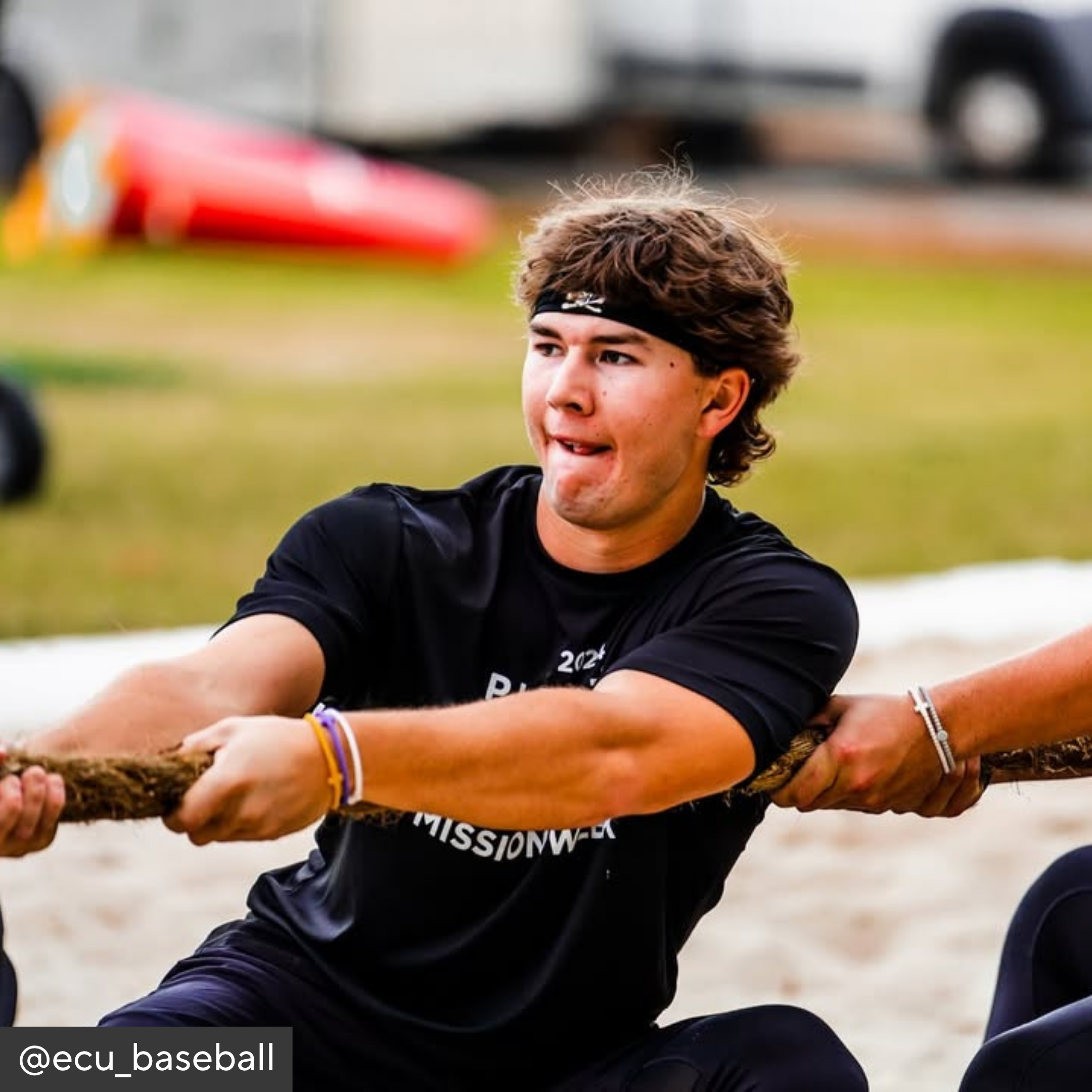 Person participating in a tug of war event on a sports field