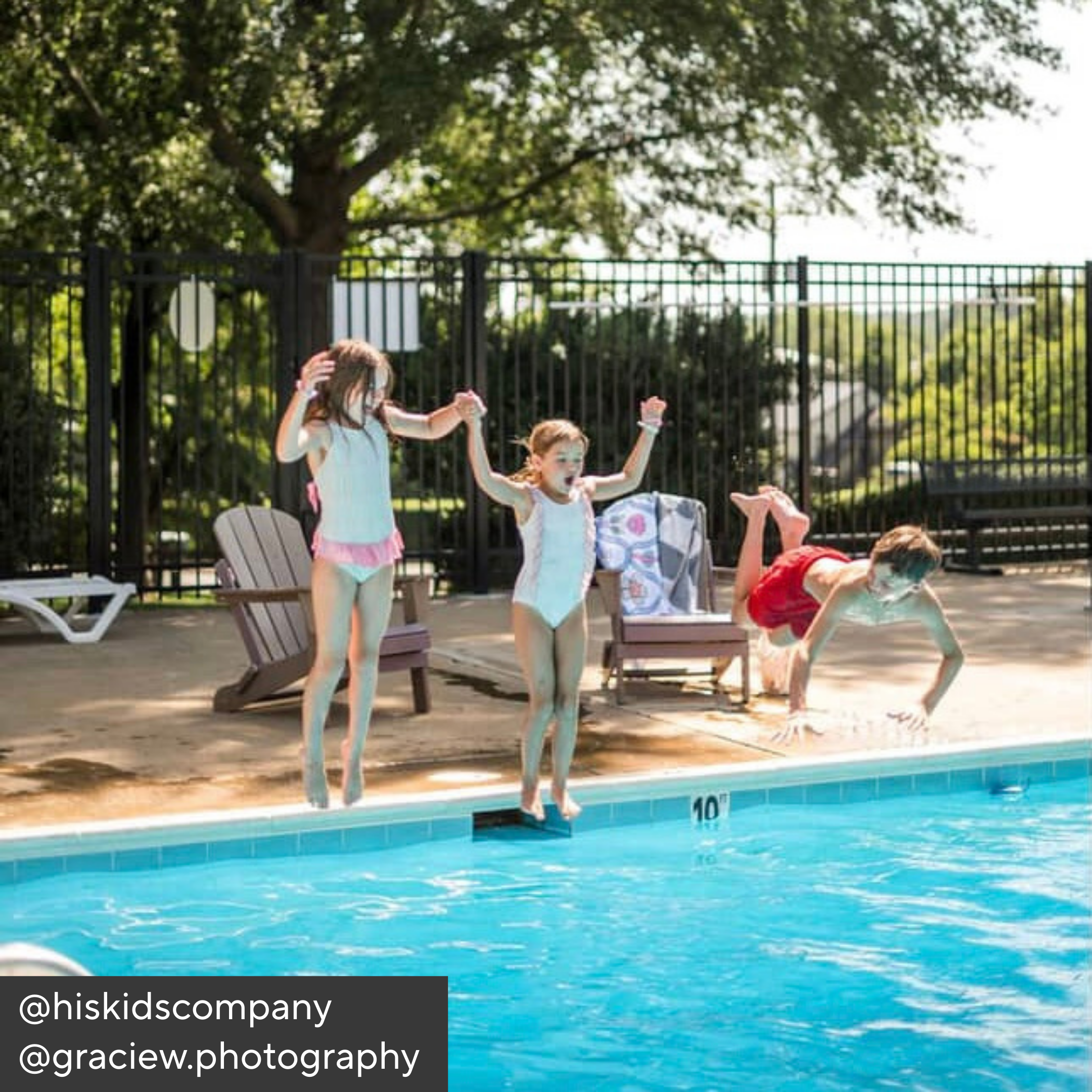 Children playing by a pool with lounge chairs and trees in the background