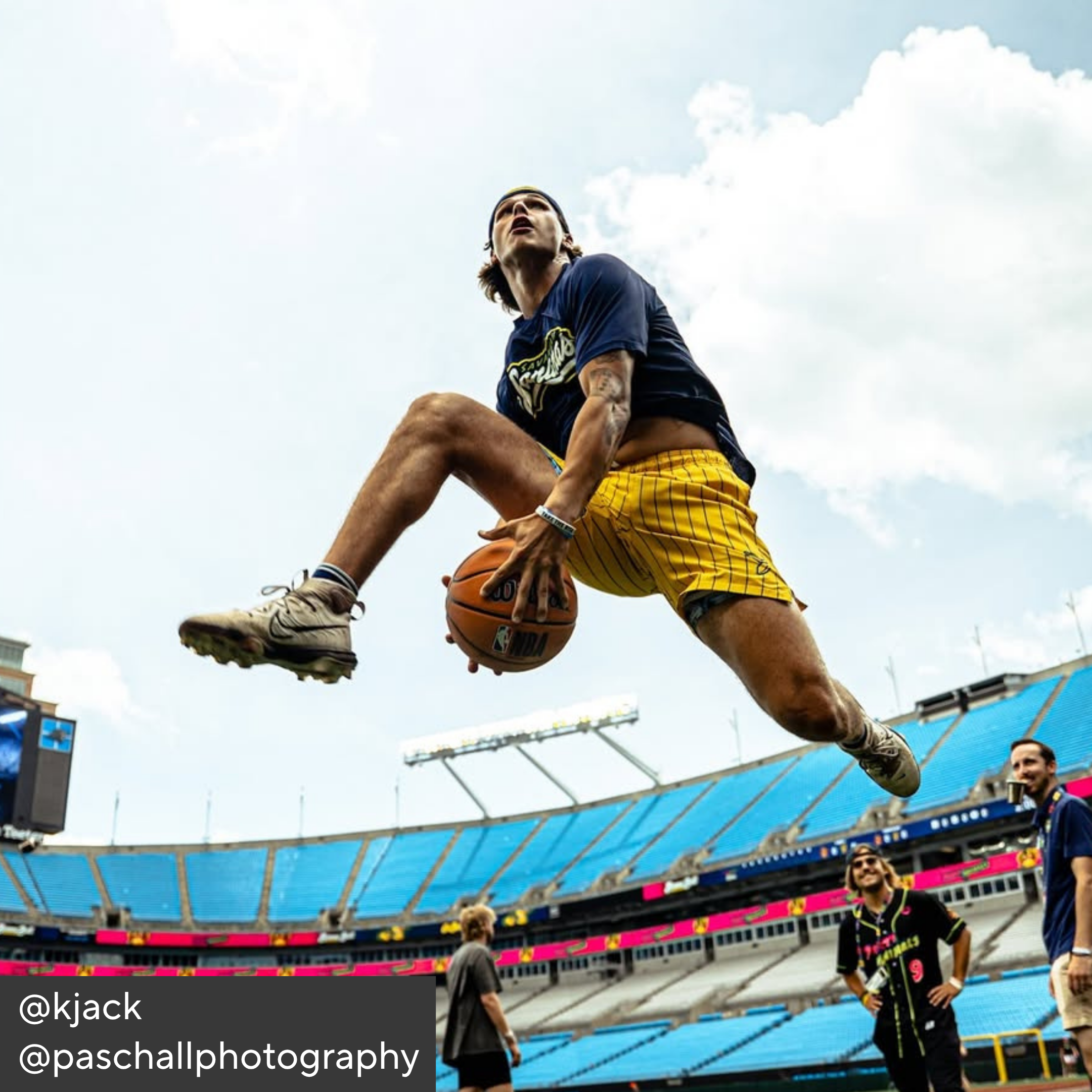 Person playing basketball in a stadium with a clear sky