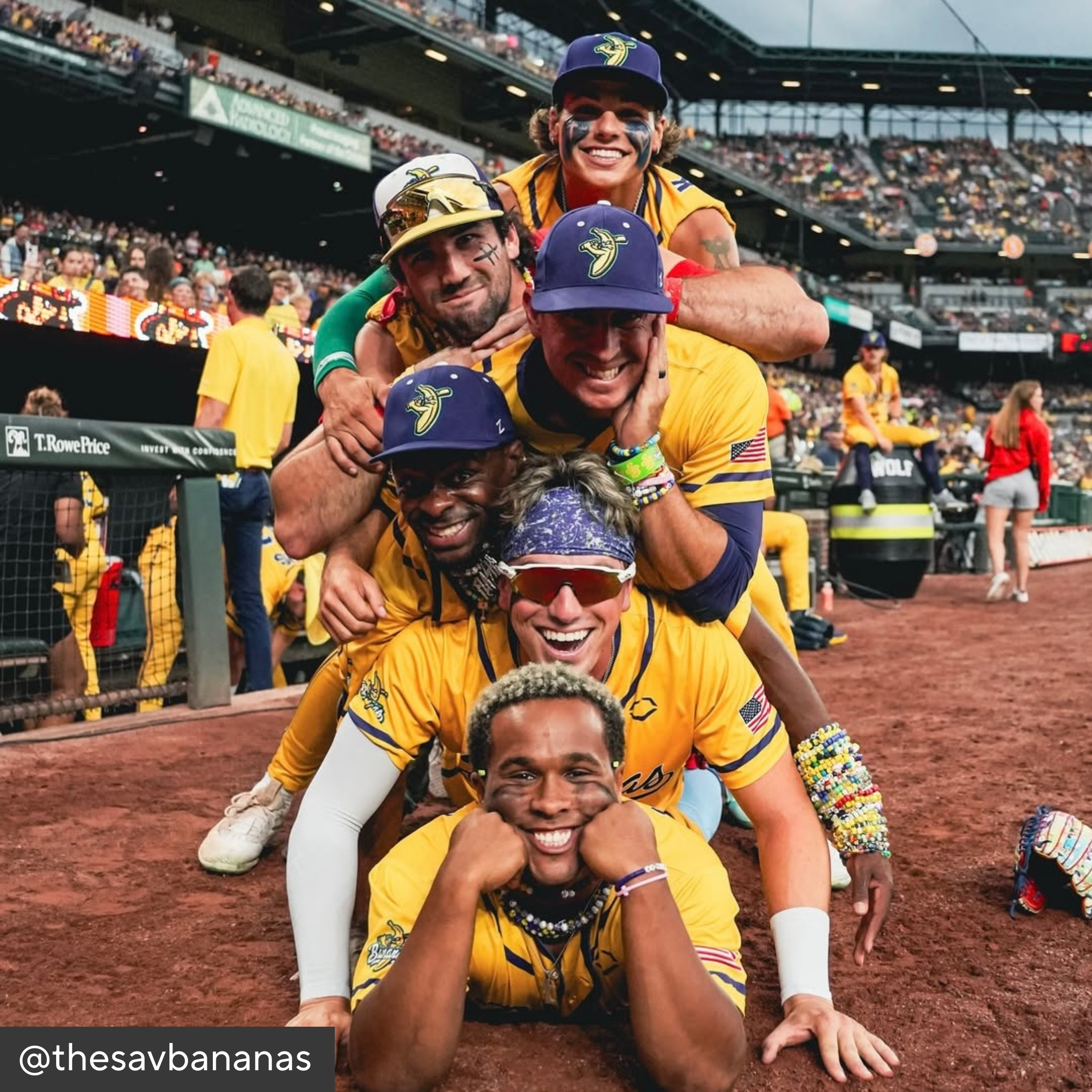 Group of baseball players in yellow uniforms posing for a photo on a baseball field.