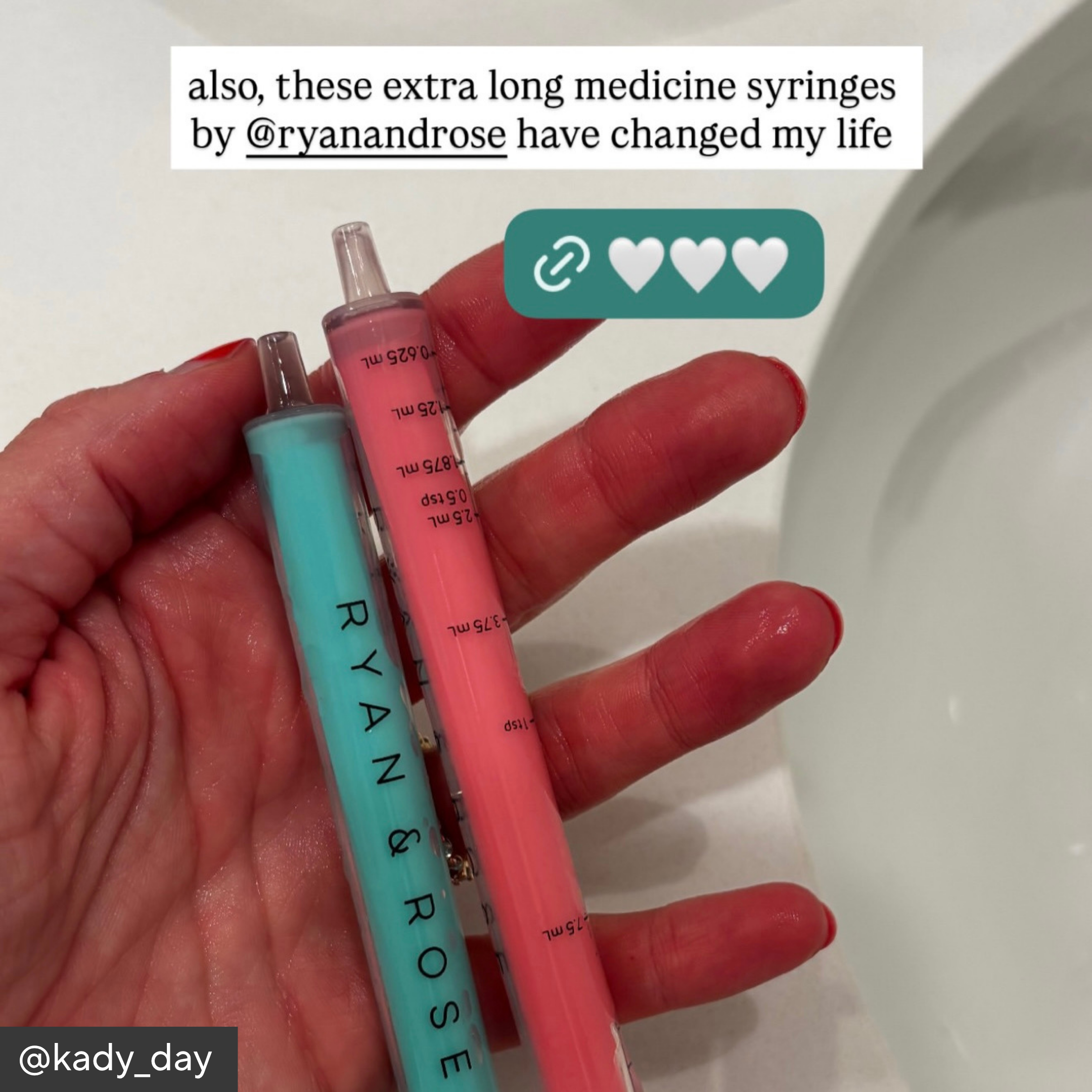 Hand holding two long medicine syringes with &