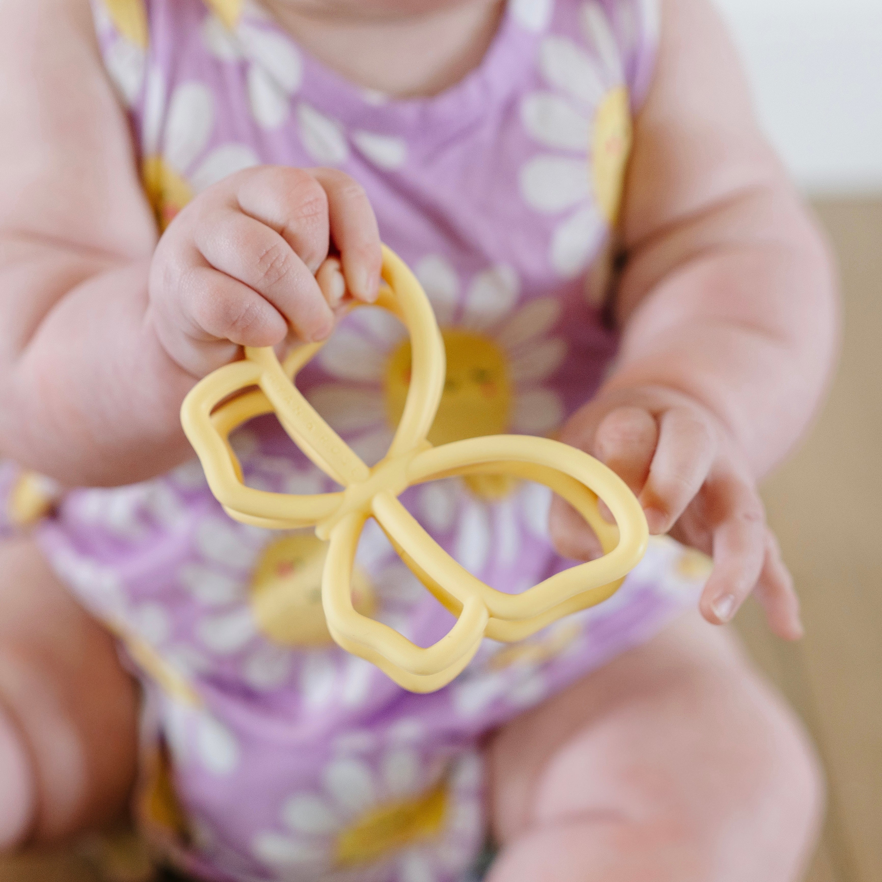 Baby playing with butterfly teether