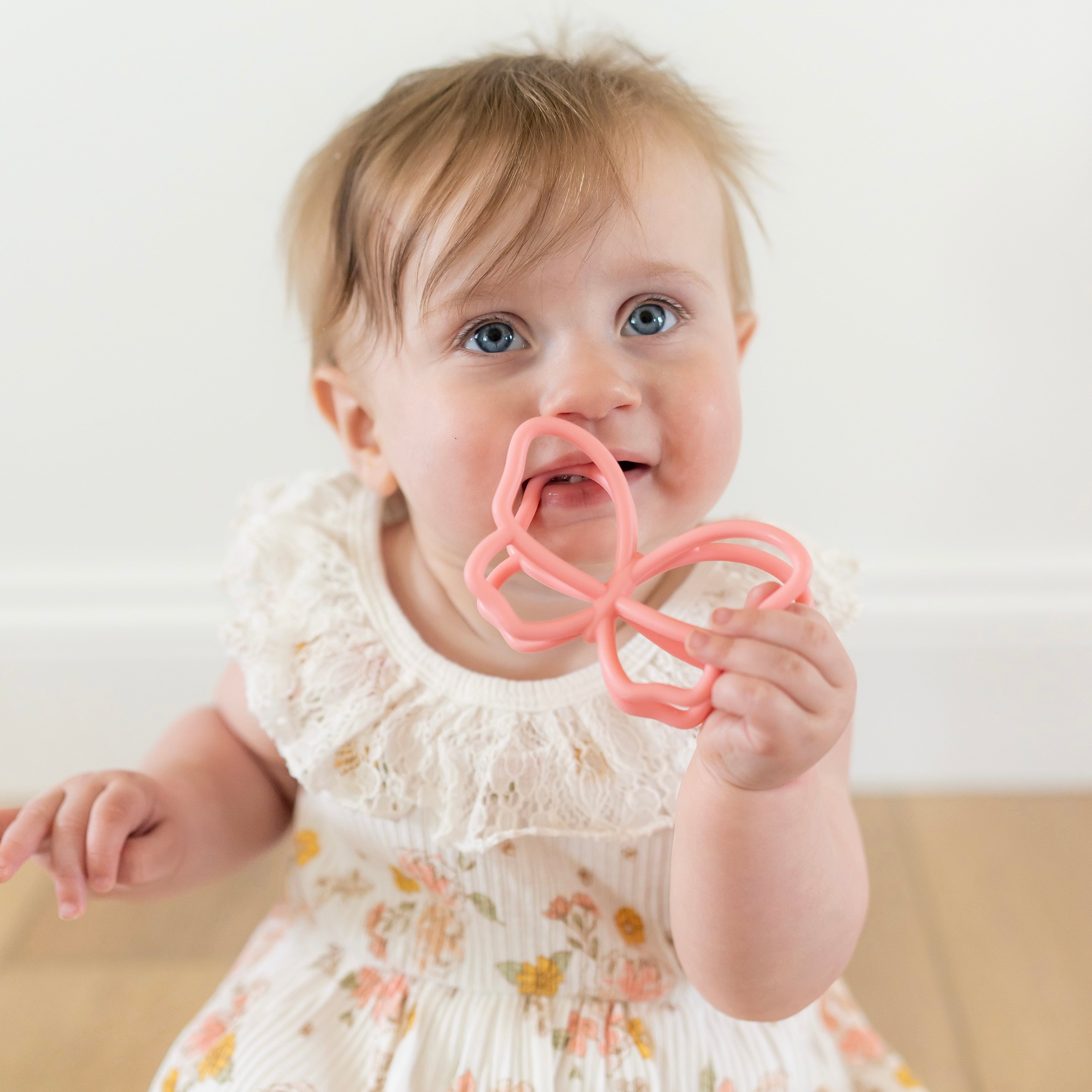 Baby playing with butterfly teether