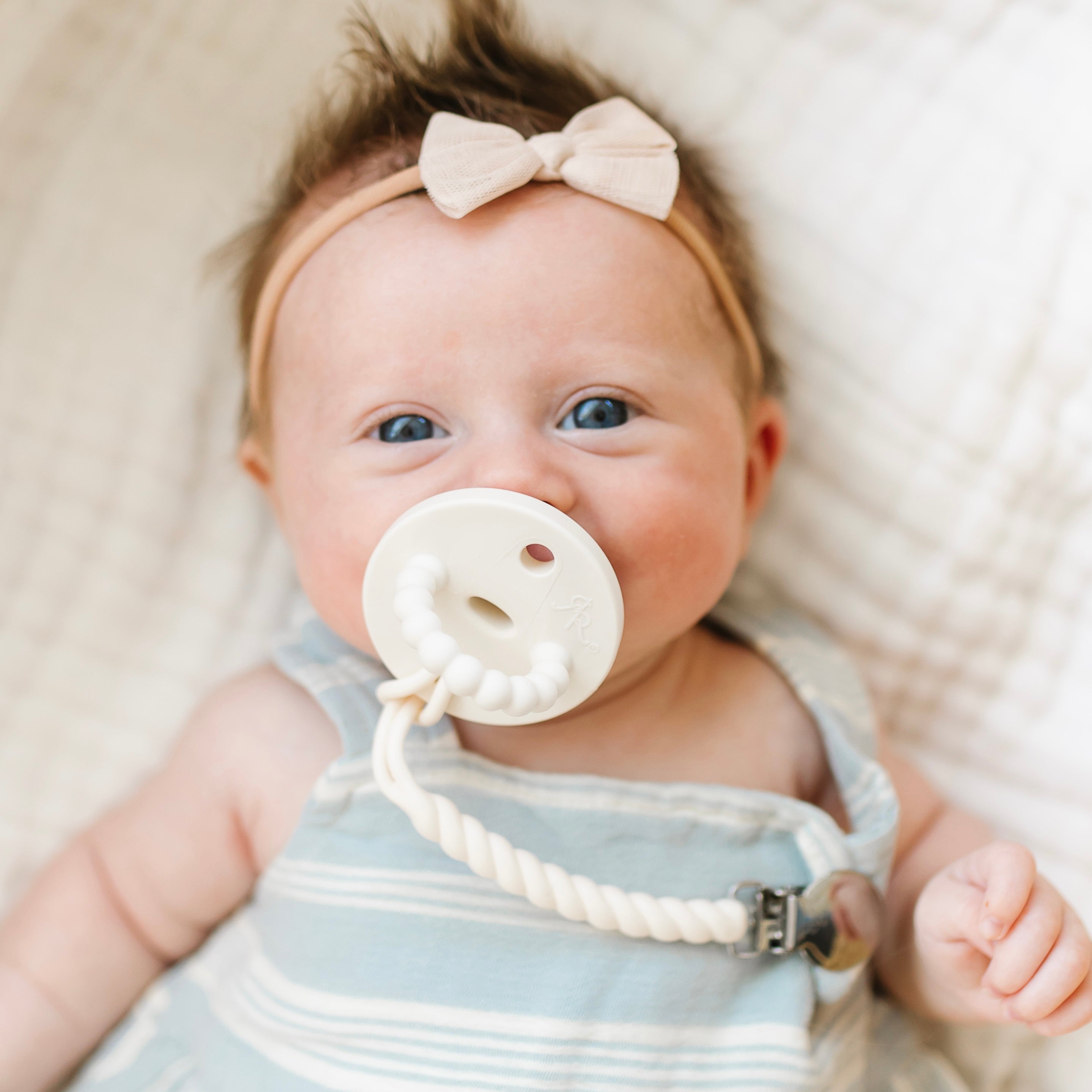 Baby girl wearing an Ivory Cutie PAT and Roper Cutie Clip.