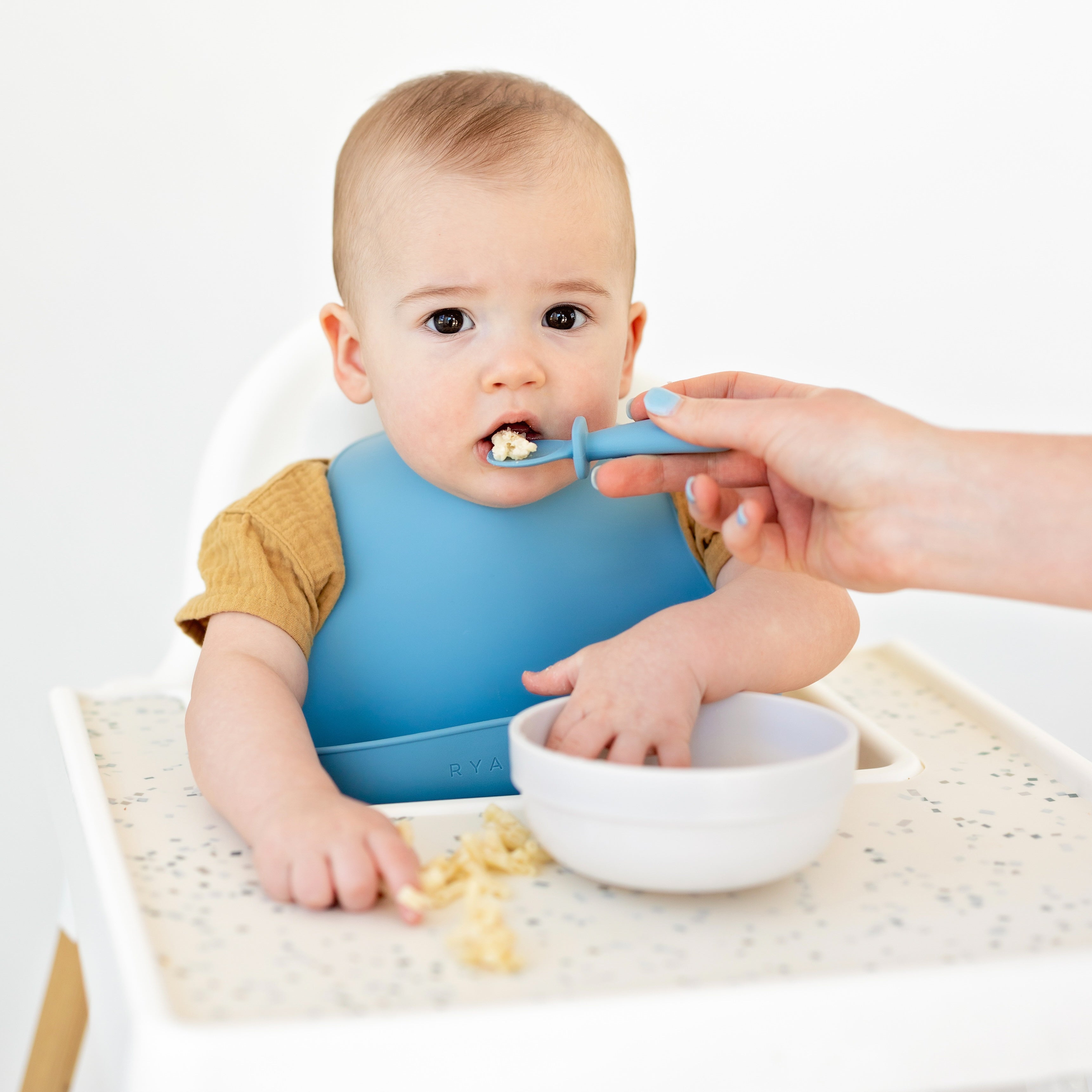 Parent feeding baby with spoonie