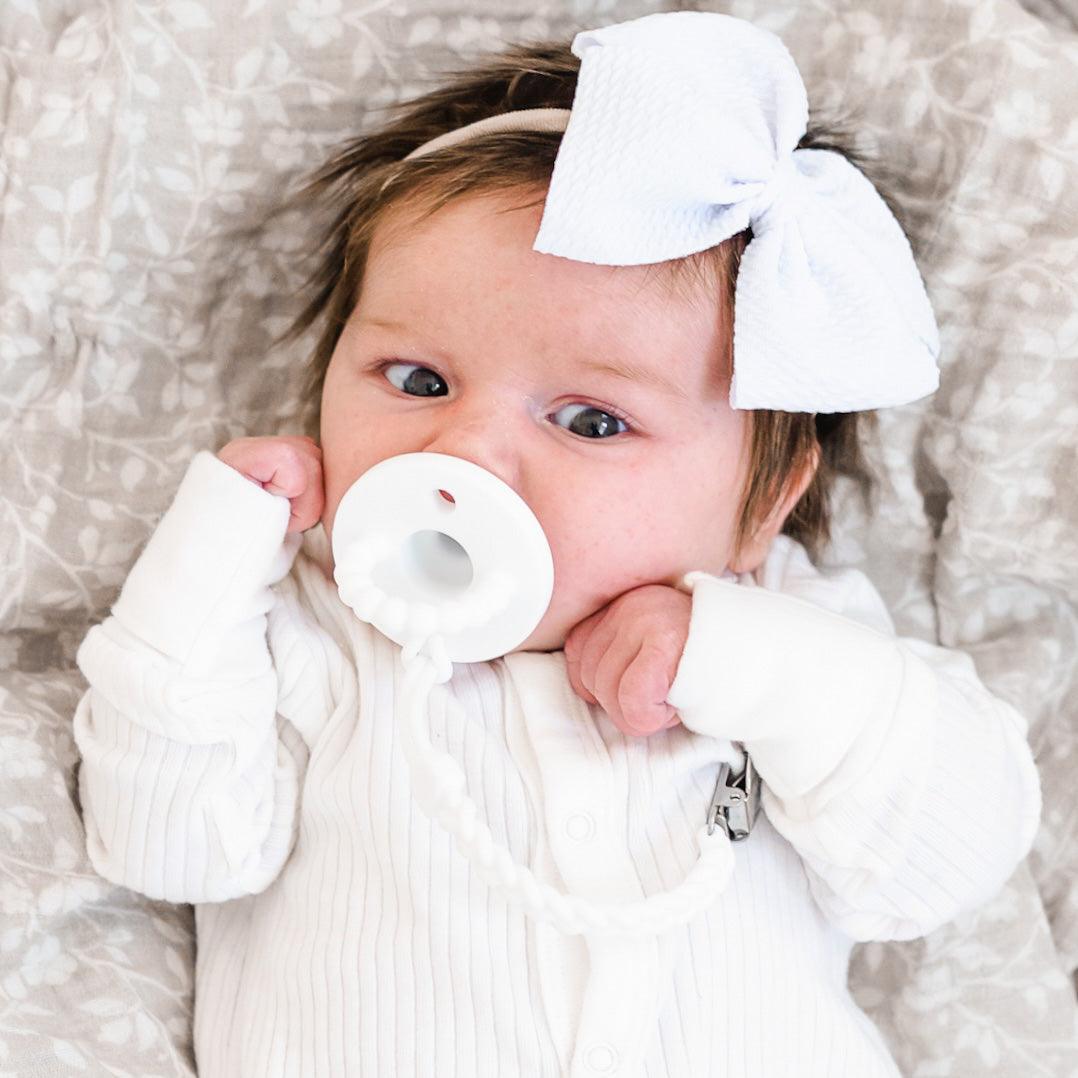 Baby girl wearing a White Cutie PAT and Braiden Cutie Clip.