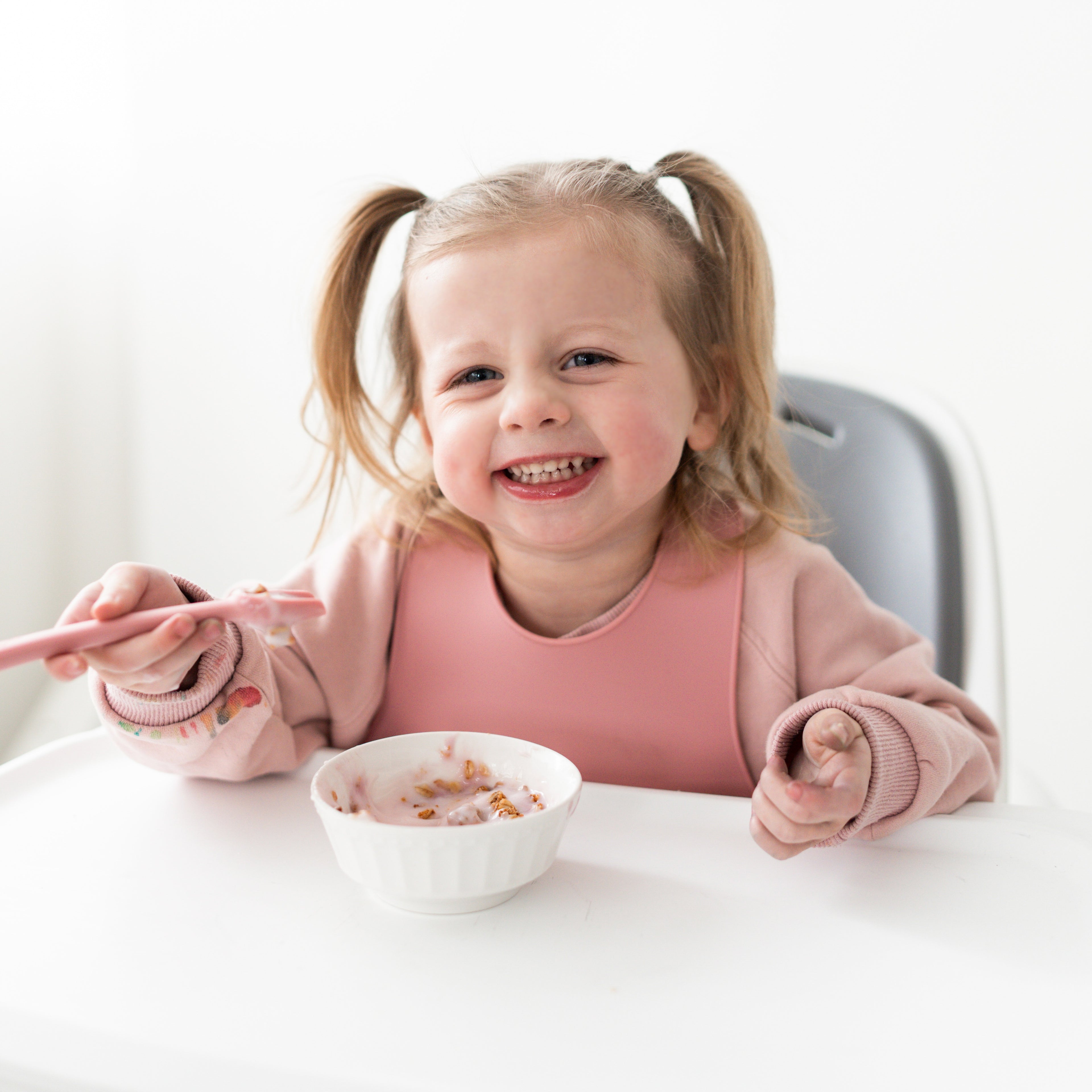 Baby in a high chair eating with Ryan &amp; Rose accessories