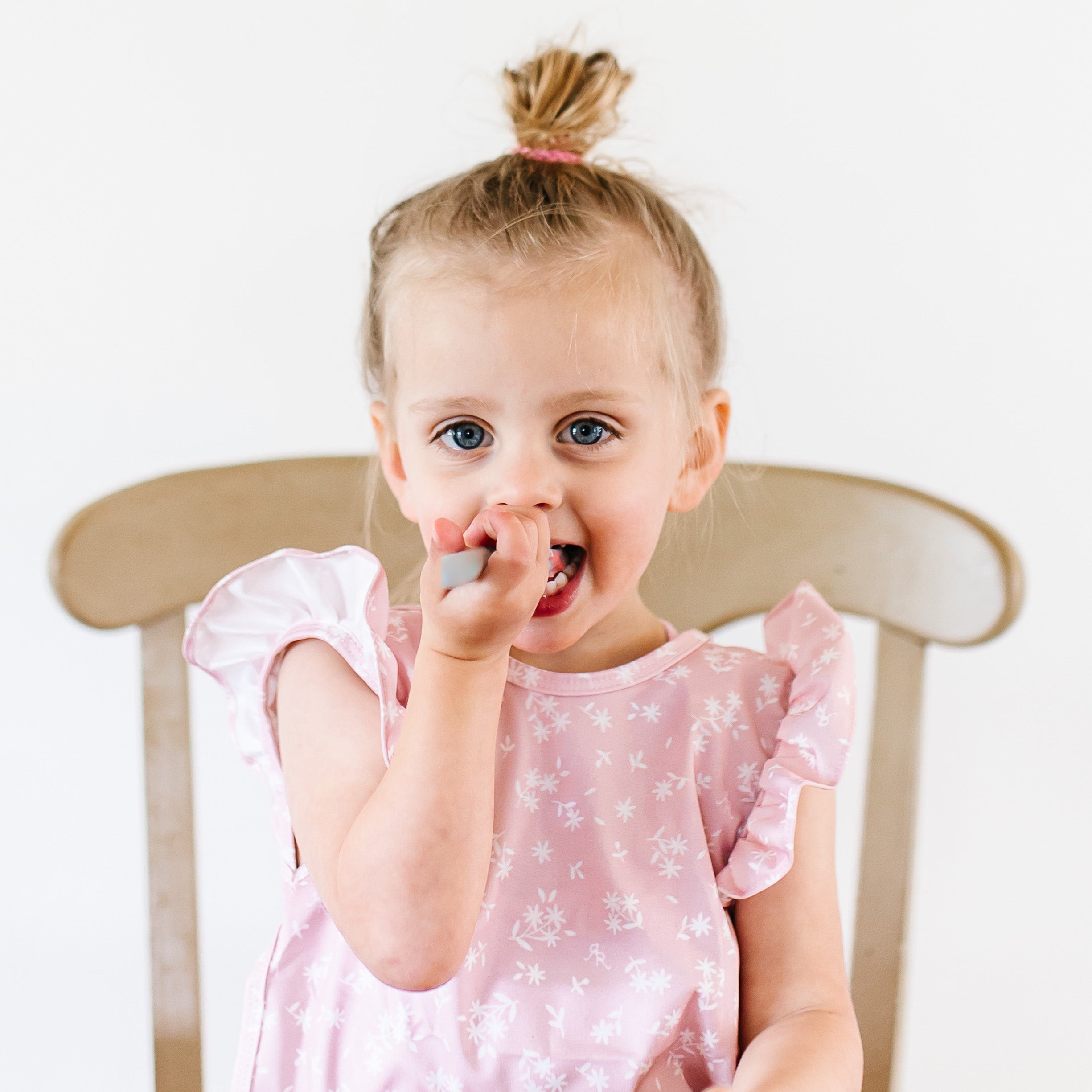 Girl eating and wearing the Pink Floral Cutie Bapron.