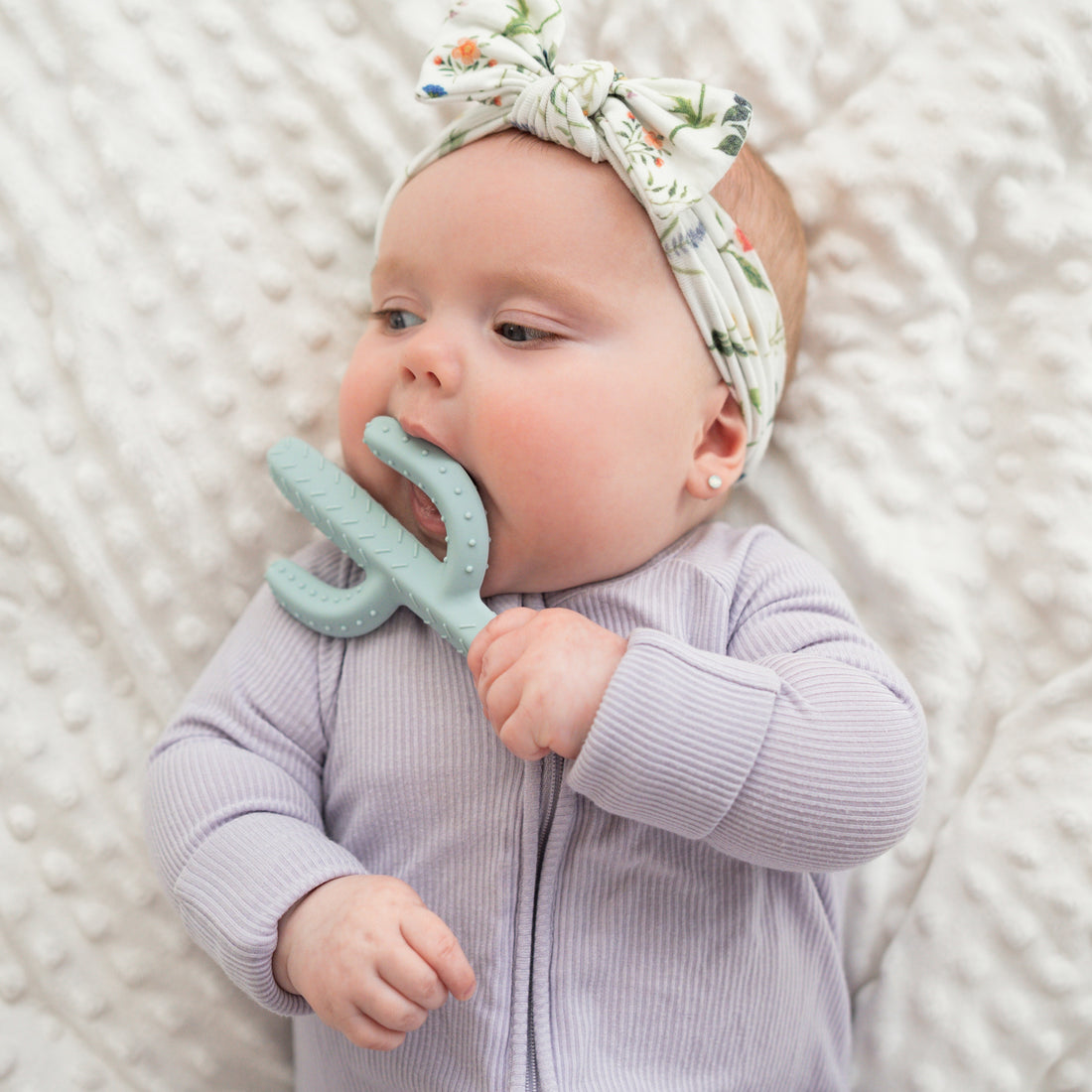 Baby chewing on cactus teether toy