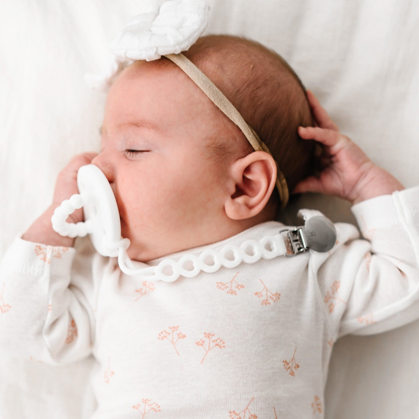 Baby girl wearing a White Cutie PAT and Hart Cutie Clip.