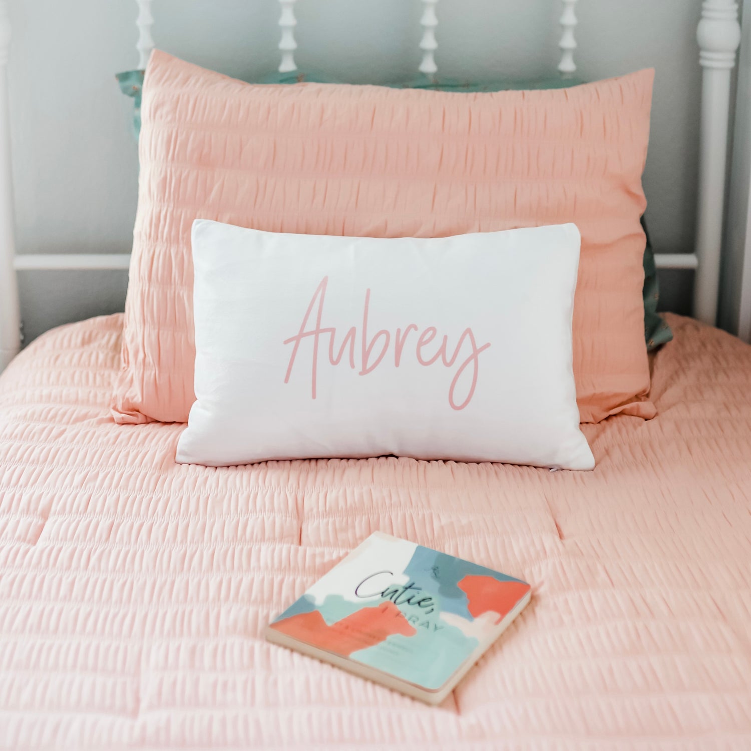Cutie pillow with a book on a bed