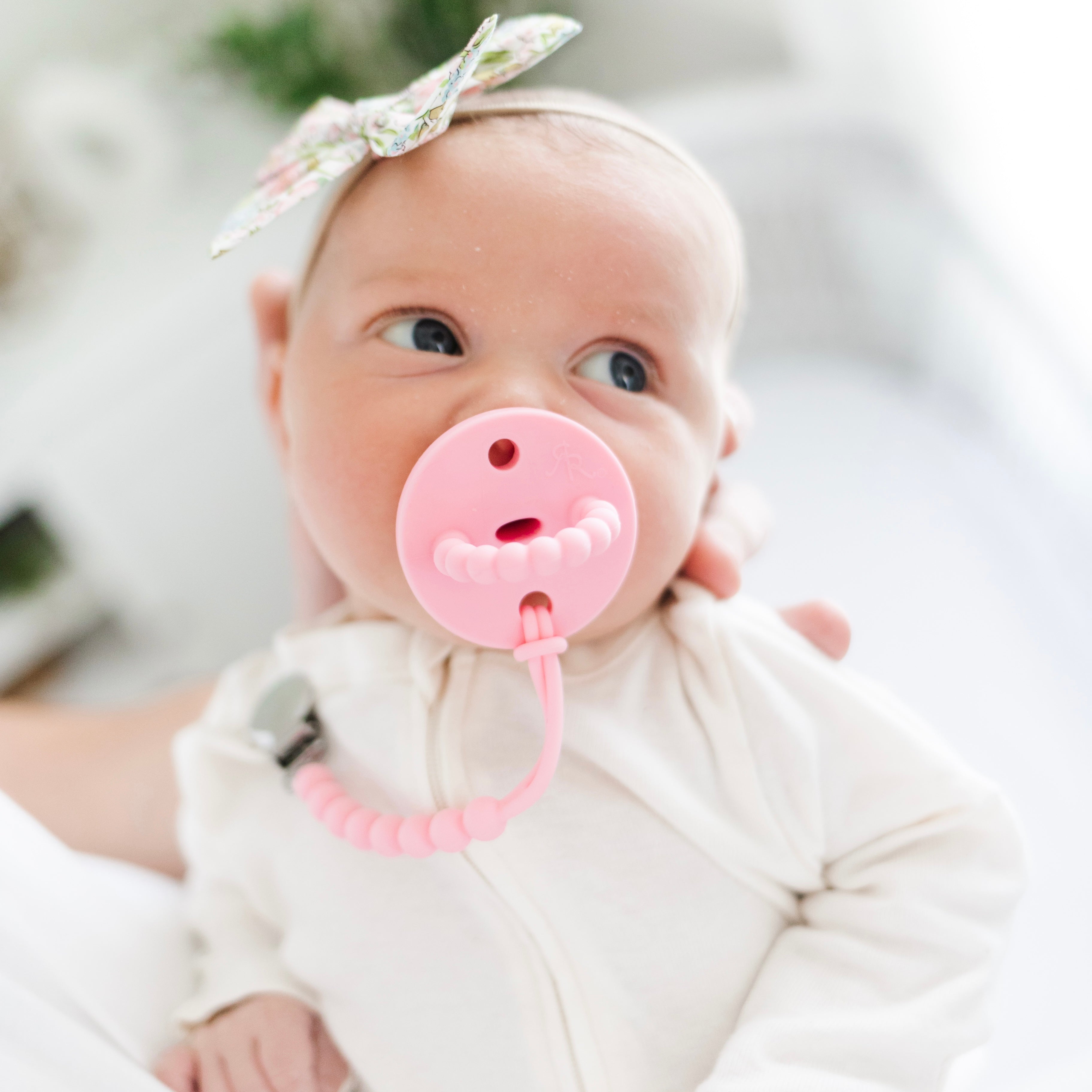 baby wearing a pacifier and pacifier clip
