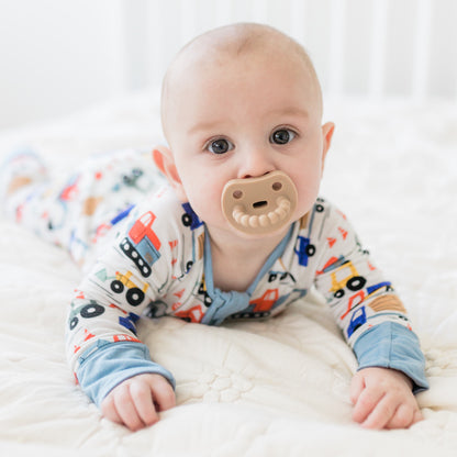 Baby sucking on a Cutie PAT Smile pacifier.