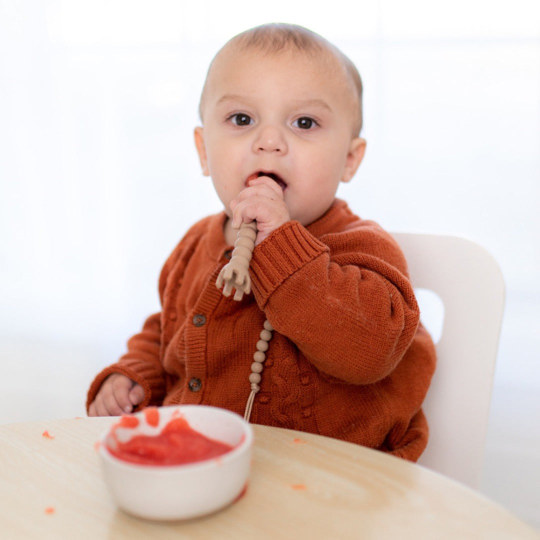 Boy sitting at table using Cutie Tensils.