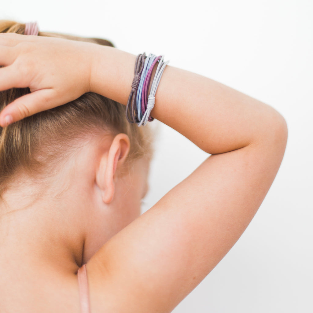 Girl putting Cutie Bangles in her hair.