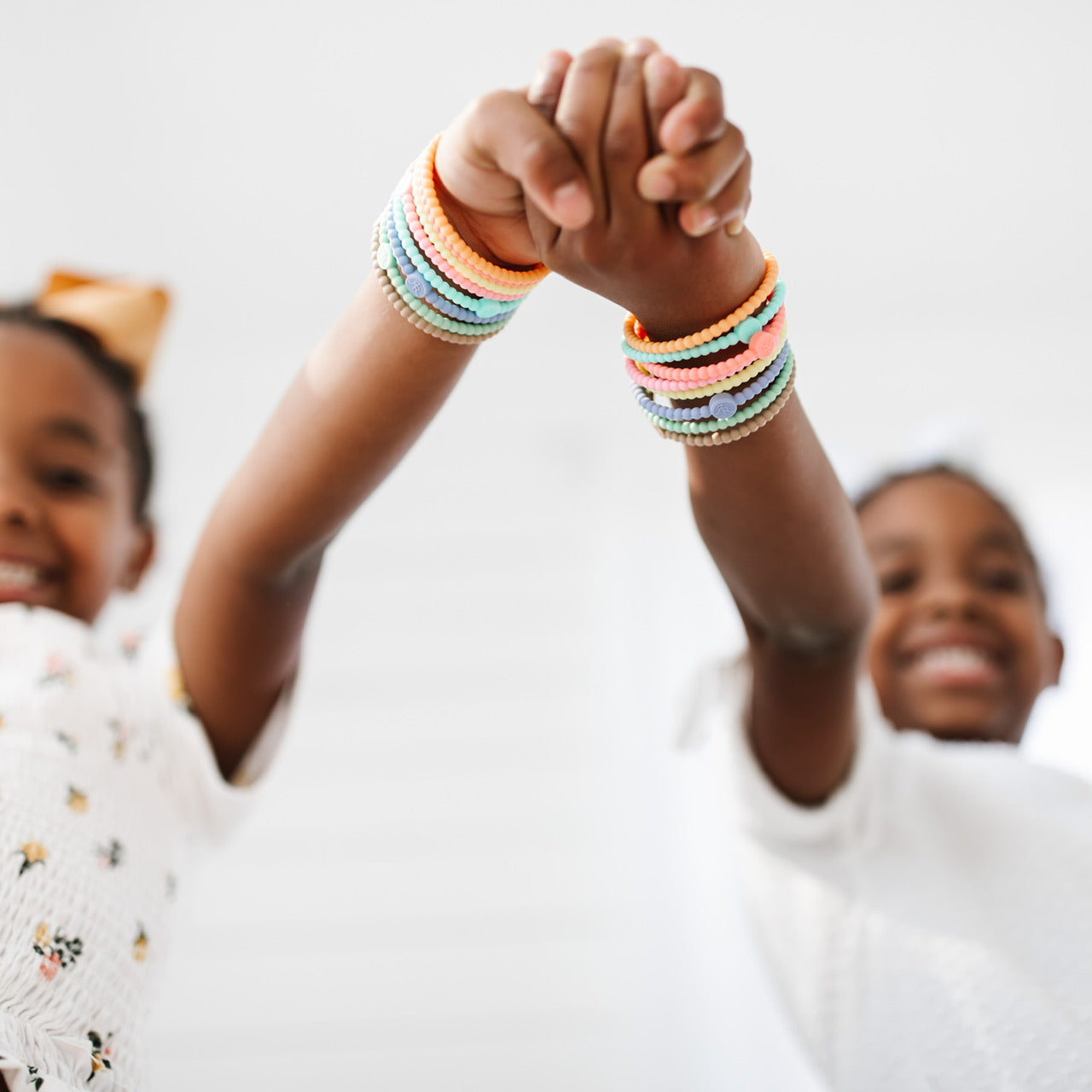 Two girls wearing the Spring 2021 Cutie Bracelets.