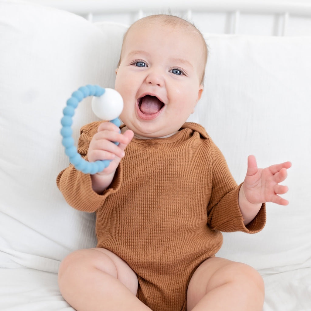 Baby boy holding the Oxford Cutie Teether.