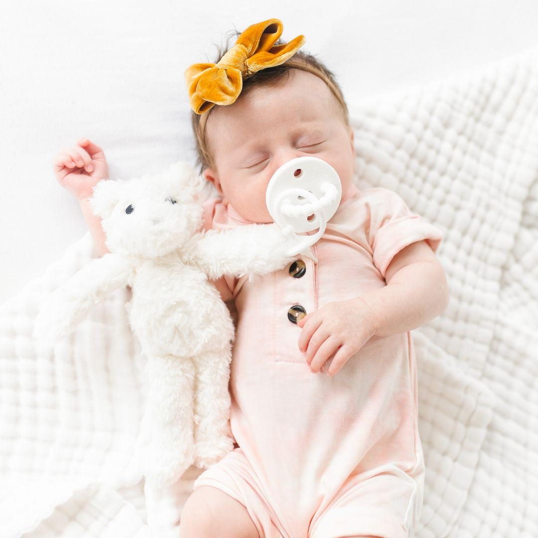 Baby using a White Cutie PAT attached to a White Cutie Cuddle.