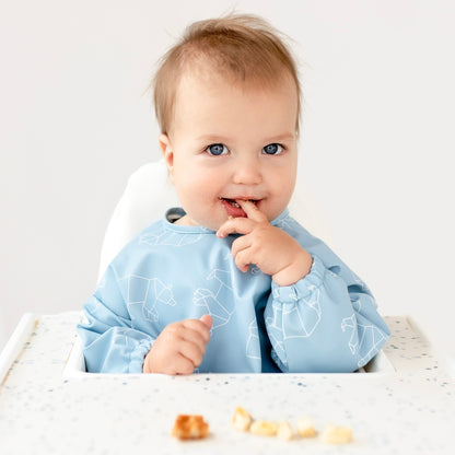 Boy sitting in high chair wearing the Oxford Bear Cutie Bib.