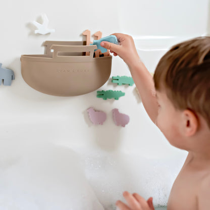 Toddler in bath tub playing with Noah’s Ark toy