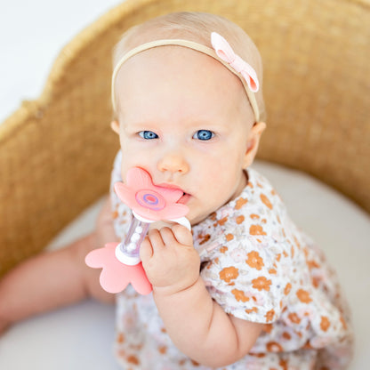 Baby playing with a flower rattle toy