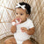 Baby girl teething on the Rose Cutie Teether.