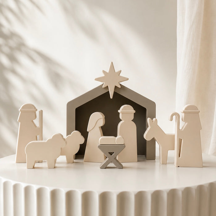  Christmas nativity set displayed on a white pedestal, featuring a stable, star, baby Jesus, Mary, Joseph, shepherd, and donkey in a minimalist, warm off-white color.