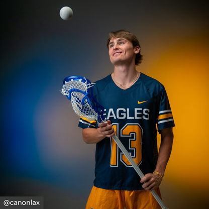 Person holding a lacrosse stick with a colorful background