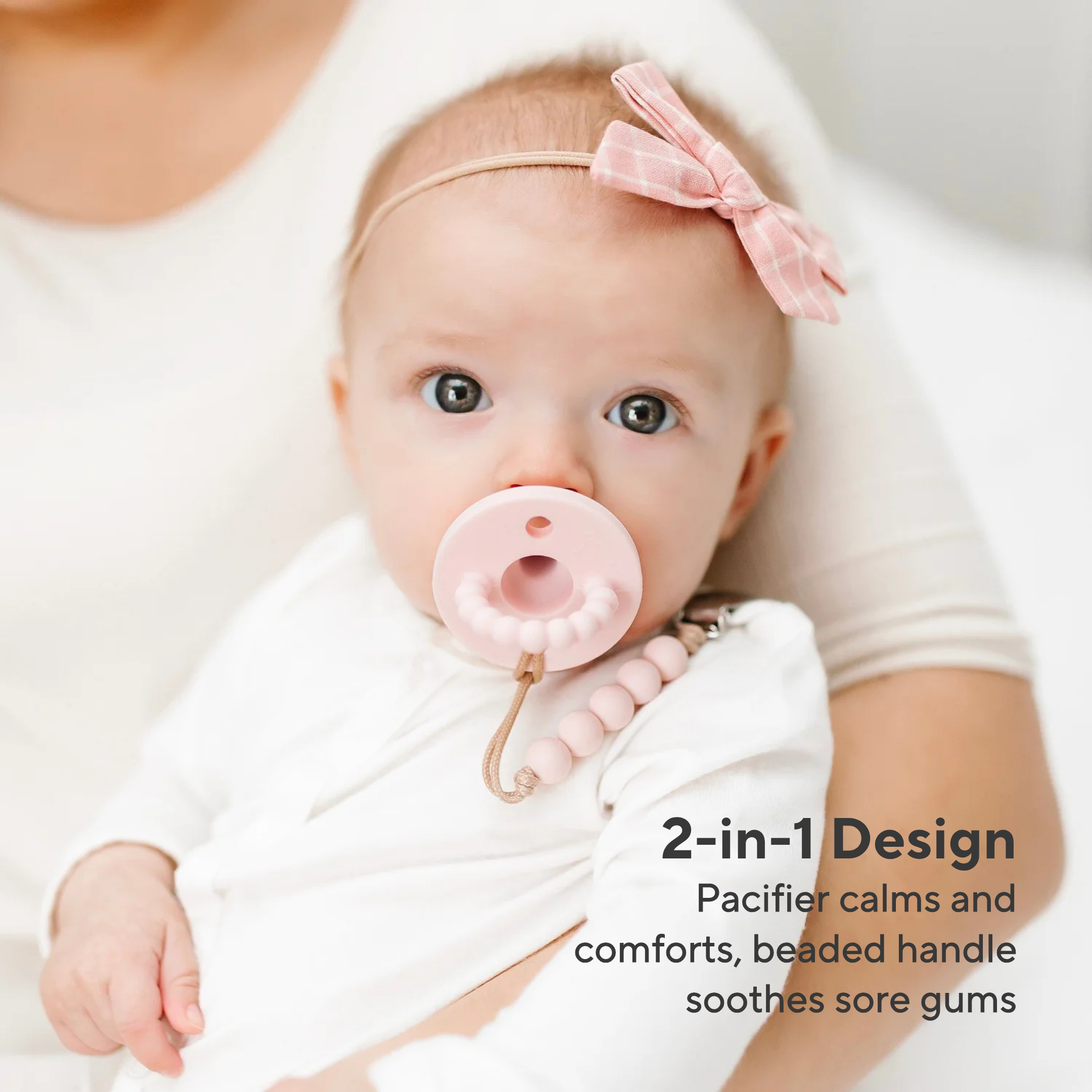 Baby wearing a pink pacifier with text about its design