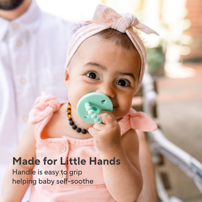 Baby with a teething ring and text &